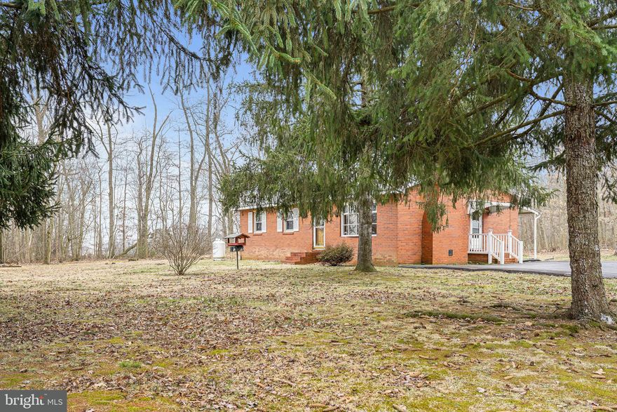 Turn up the long drive to a rare quiet and gentle place where pride in family and home is evident by happy memories which you will share for years to come.  This Well-Built home with over 8 acres to enjoy the sunshine and wonderful sounds of Mother Nature. Three bedrooms and two baths all on the main level.  Kitchen flows nicely to the dining room area, and the large living room has a wonderful brick wood burning fireplace to sit in front of on those cozy winter nights.  Living room and bedrooms have gleaming hardwood floors. The lower level can be finished and has a second wood burning fireplace for your entertainment nights playing games or just visiting.  The lower level also has a small woodworking room and walk out with bilco doors to the backyard.  There is a back patio where you can sit and enjoy relaxing in your back yard.  The 3 bay outbuilding needs a little work but has electric to it and lots of room for a vehicle, workshop or storage.  House generator included 
This rare find with a delightful setting has endless possibilities only limited by your imagination.  It is being sold "as is" but major utilities are newer.  Kitchen appliances are working but also being sold in "as is" condition.