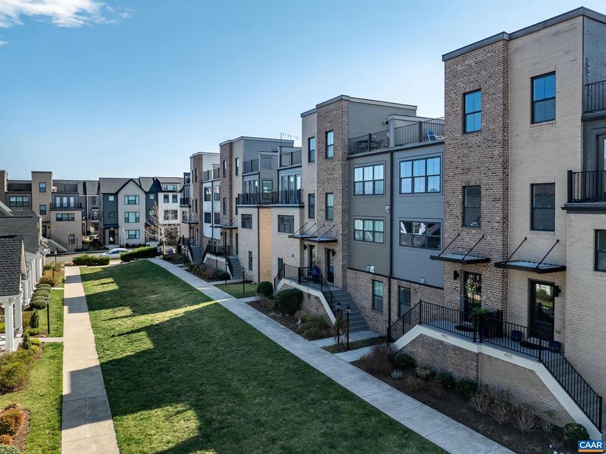 The views!!  Amazing!  Discover an extraordinary living experience in Old Trail, where this stunning four-story, townhome on green space combines modern design with breathtaking mountain vistas walkable to the Town Center. Step inside to an inviting, light-filled interior featuring espresso colored hardwood floors. The stairwells have been opened, creating a sense of spaciousness and elegance. The heart of the home is an open-concept living area with a gourmet kitchen that boasts modern gray cabinetry, luxurious granite countertops, tile backsplash, and functional island. The home's thoughtful layout maximizes both comfort and functionality. The bedroom level showcases a generously sized owner's suite with walk-in closet and a spa-inspired bathroom, featuring a sleek frameless glass shower. Two additional bedrooms provide ample space for family or guests. The ground floor offers versatility with a fourth bedroom/home office/home gym with upgraded carpet. Perhaps the true gem of this property is the spectacular rooftop terrace?an urban oasis with panoramic mountain views that will become your favorite retreat. Practicality meets luxury with a two-car garage and a convenient rear deck for outdoor dining and grilling Don't miss out!,Granite Counter,White Cabinets,Wood Cabinets