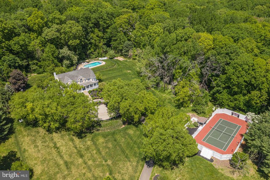Spanning over 4 acres and situated atop a peaceful neighborhood setting is 2977 White Tail Court, a totally unique and one-of-a-kind property which includes a separately deeded, potential building lot!! From the beautiful wrap around porch offering gorgeous long distance and scenic views with surprises around every turn while feeling like you are secluded in your own private sanctuary. The spacious floorplan is perfect for everyday living and features idyllic spaces for both entertaining and relaxing with virtually every room offering access to the gorgeous porch and the option for every room to be closed off for privacy. Drive right up to the paver courtyard and enter through the welcoming front door into the grand 2 story foyer with hardwood floor which opens to the rest of the home and has a lovely view straight through to the landscaped rear yard paver patio. The elegant 2 story dining room features architectural columns, a spacious butlers panty and French doors that frame the picturesque views of the rear yard. The formal living room boasts a marble fireplace, deep crown molding and views of the pool. A cozy office can be closed off for privacy from the rest of the home by two sets of French doors. An abundance of natural light fills the kitchen which opens seamlessly into the gathering room. Boasting a coffered ceiling, double wall ovens, paneled SubZero refrigerator and an oversized granite island with seating. The breakfast room with its walls of windows and French doors offers additional flex space which could be used as an office, child homework area or exercise room. The window filled gathering room has beautiful outside views and features a wall of built-in cabinetry, plantation shutters and access to the front and side porch. Enjoy morning coffee or evening beverages outside on the porch year round while taking in the scenic Bucks County views. Completing the 1st floor are 2 half baths and a large drop zone/mud room area. Head upstairs by either the main or rear staircase to the spacious hallway overlooking the foyer and dining room. The main suite features a sitting room surrounded by windows, a vaulted ceiling, 2 walk in closets with built-ins and access to its own private balcony. The sprawling main bath offers an oversized dual vanity area with a stylish glass block wall, separate water closet area and separate tub area. Four additional bedrooms are on this floor. Two share a Jack and Jill bath, the other 2 share a hall bath and one has its own sitting area and access to the upper porch. The laundry is conveniently located on this floor. The 3rd floor has been finished an offers additional living space which could be used as a bedroom, office or studio. A daylight walk out basement opens to the pool area and offers a media area, studio/exercise room, office/flex room, large game/billiards room and a half bath. Outside you have your own recreational area! Perfect in time for the warmer weather, much time will be spent outside enjoying the pool and outside amenities with family and friends, or entertaining in one of the outdoor living spaces or using the sports court which can be closed off for privacy and safety. Additional home amenities are a 3 car garage, recessed lighting , newer carpet and paint and includes a potential building lot, separately deeded! This custom built home is conveniently located near Doylestown Boro, Peddler’s Village and New Hope. Central Bucks School District. Enjoy everything this home has to offer both inside and out. Schedule your tour today.