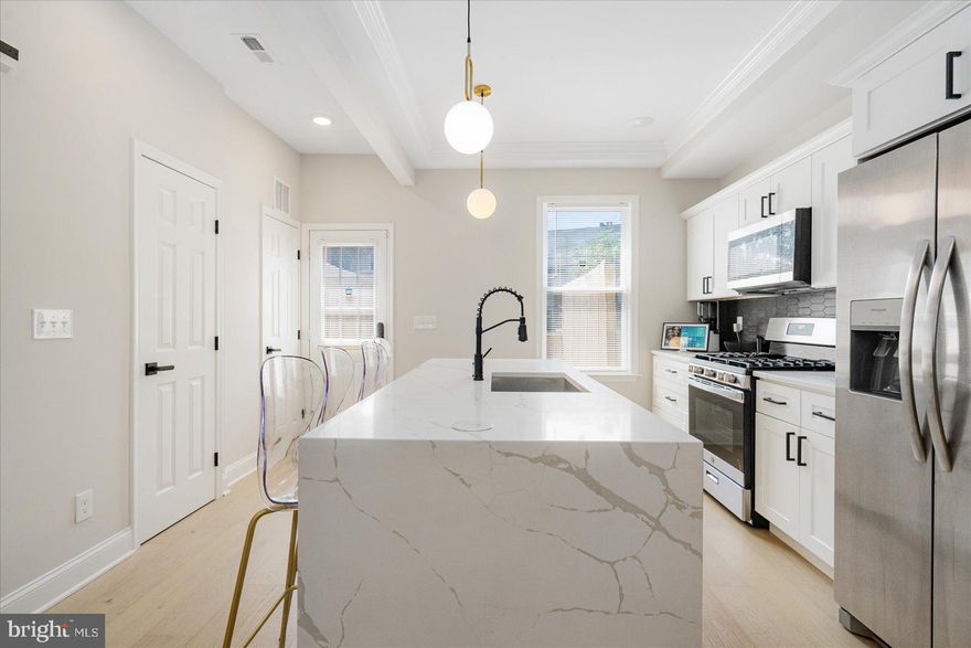 WOW!!! Sometimes, opportunity does more than just knocks! NEW PRICE! Welcome to Greenspring Estates - A Turnkey Gem in the Heart of Baltimore! Truly a "smart home", this one is so smart that the BGE bill hovers around those of tiny one bedrooms. Seriously! From the smart HVAC, to the insulation, to the high efficiency lighting, mechaincals, etc., this meticulously cared-for townhome blends modern luxury, smart design, and thoughtful upgrades you won’t find in nearby listings. Why? Because this isn’t a quick flip—it’s a nearly new construction from the ground up, with everything redone down to the pipes. The difference? You’ll feel it the second you walk in. Step inside to an open-concept floor plan full of natural light, anchored by a dramatic coffered ceiling, oversized industrial fan, and a stunning LED fireplace feature wall. And just when you think it can’t get better - BOOM - you’re in the designer kitchen: waterfall quartz countertops, stainless steel appliances, tray ceilings, sleek backsplash, touch faucet, USB charging ports, and room to entertain, cook, and live. Walk out to your private deck overlooking your off-street two car parking pad - no rear yard to mow, just peace of mind and a place to sip your morning coffee. Upstairs, the primary suite stuns with a massive walk-in closet and spa-like bath. Two more spacious bedrooms and a full bath complete the level. Head downstairs and unlock serious bonus space: a finished basement with a bedroom, office/flex space, wet bar, and second living area - perfect for guests, a gym, podcast space, YouTube cave, or your favorite late-night hang. Other highlights include: 2 LED fireplaces, state-of-the-art security system with cameras, tight-knit, rehabbed block with community group chat, a possible FHA loan assumption potential for qualified buyers (a rare perk in today’s market) and so much more! Most importantly: this isn’t just a house - it’s a home with intention, owned and loved by someone who's been here from drywall to doorbell! A must see? Sure... but really... a MUST EXPERIENCE! Bank is ready to make a deal! Let's do this!!!