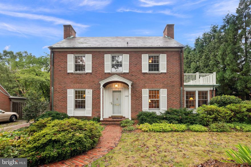 Open Sat/Sun (October 5-6) 2:00-4:00 pm. This expanded Lyon Village Colonial is perfectly positioned along the coveted Orange Line Metro corridor, offering the best of urban convenience and timeless architectural appeal. With its classic brick facade and symmetrical Colonial Revival design, this home is a prime example of the craftsmanship of renowned architect/builder Frederick (Fritz) E. Westenberger, who shaped much of the area’s charm during its early development. Ideally located on the western side of Lyon Village, this 7,750-square-foot lot is a private retreat featuring mature trees, lush landscaping, a water feature, a patio for outdoor living, and an oversized 2-car detached garage. The home has been thoughtfully expanded by the current owner, who oversaw the addition of a spacious kitchen and upper level primary suite with balcony overlooking the rear yard. From the welcoming foyer, hardwood floors lead you into the formal living and dining rooms, where the home’s warmth and elegance shine. The living room, located at the front of the house, boasts a fireplace and built-in bookshelves, and connects seamlessly to both an office/den and a generous great room at the rear. The kitchen and family room addition is a bright and open space with vaulted ceiling, offering an eat-in area surrounded by large windows that flood the room with natural light. Adjacent, the great room features additional built-ins and French doors that open to the charming rear patio—perfect for indoor-outdoor entertaining. A conveniently located guest bath completes the main level. Upstairs, you’ll find a spacious primary suite, accompanied by three additional well-sized bedrooms. One of these bedrooms enjoys its own ensuite bath, while the remaining two share a full hall bath, ensuring comfort and privacy for all. The finished lower level offers even more living space, with a cozy family room, a second wood-burning fireplace, built-ins, a full bath, and utility room, we well as extra storage areas to meet all your needs. Situated on a picturesque, sidewalk-lined street, this home is just a half-mile from the Clarendon Metro and within easy reach of Whole Foods, popular restaurants, coffee shops, and boutique shopping. Mere blocks away from Lyon Village Park, with tennis, basketball and playground. With an international airport just 5 miles away, the world is at your doorstep—yet you might never need a car.