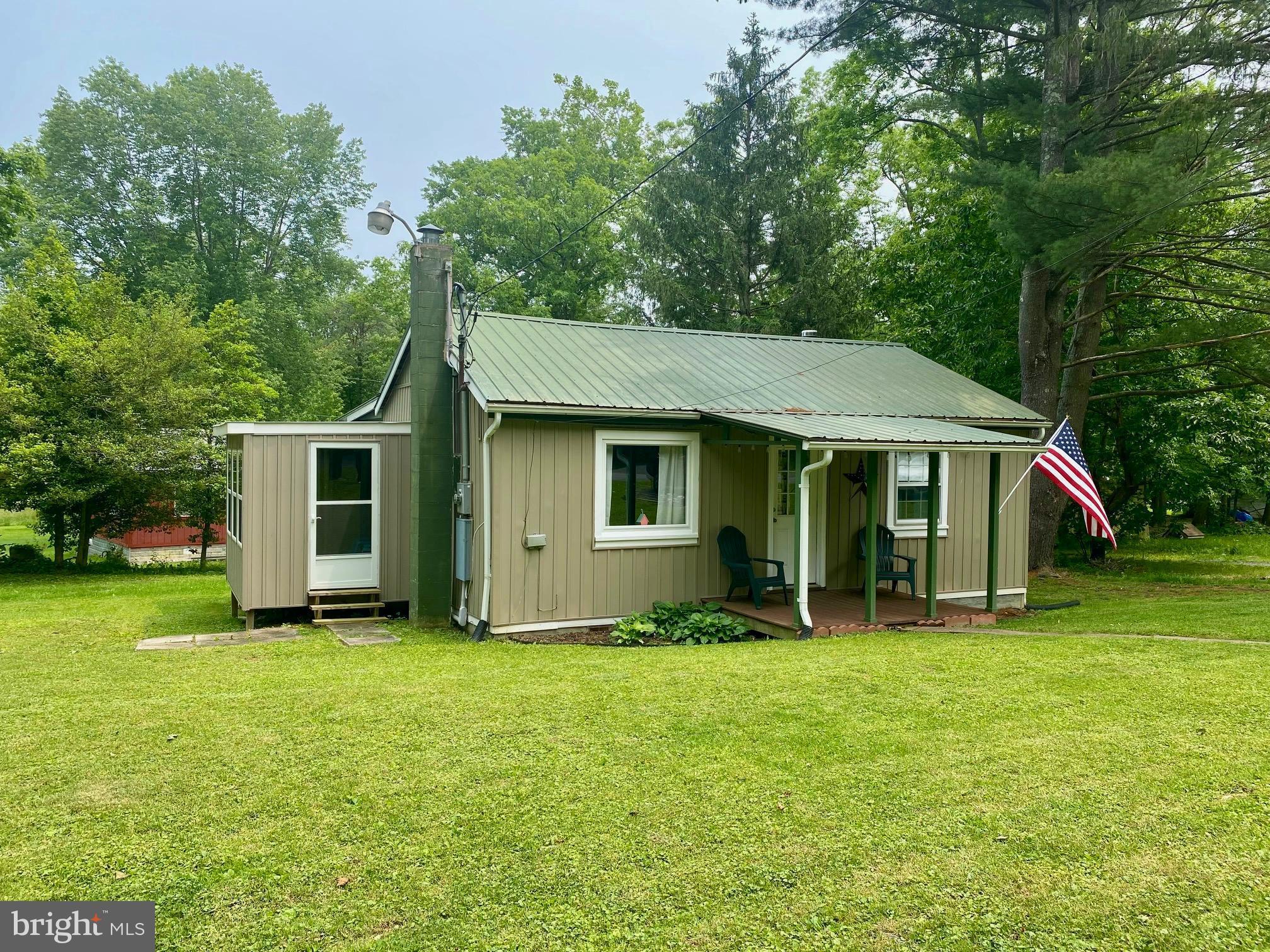 How are you gonna spend your summer? Escape to this charming and well-maintained cabin nestled in a friendly campground with direct access to the scenic Cacapon River—perfect for kayaking, fishing, or simply relaxing by the water. This mostly furnished retreat is move-in ready and features two cozy bedrooms, one full bathroom, central heat and air for year-round comfort, a relaxing three-season room, and a covered front porch ideal for sipping your morning coffee. There's even a shed for convenient kayak storage. Best of all, this unit is not in the flood plain, offering added peace of mind. Please note: the lot is leased, making this a great opportunity for those seeking a low-maintenance getaway in a beautiful natural setting. While the camp is open year round, full time residency is not permitted.