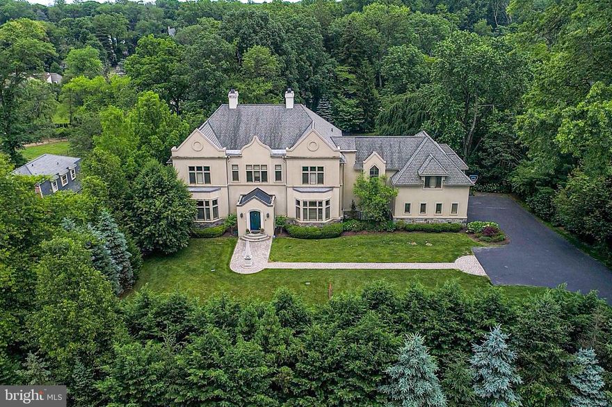 This bright and airy North-Side Bryn Mawr manor home offers nearly 8,000 square feet of living space with a striking English Tudor exterior designed by Rene Hoffman. Inside you will find expansive open interior spaces, offering up to 14 ft ceiling heights, sun-filled rooms, and wonderful open flow with views of the private 1.57 acre fully-fenced grounds. Premium finishes/amenities are abound including Brazilian Cherry & Oak hardwoods throughout the first level, high baseboards, heated garage with dog wash, beautiful custom built-ins, newly-installed electronic blinds and plantation shutters, new garage motor/tracks, upgraded landscaping in the front and rear, elevator with wood paneling and granite floors to all 3 levels, central vacuum, newly installed alarm system, whole-house wiring for audio/ethernet, recently-installed A/C unit, soaring solid wood doors and top-of-the-line hardware.There are four grand open living spaces on the main level. The living room offers Brazilian Cherry hardwood floors and a double-sided custom Limestone gas fireplace surround. On the other side of the fireplace, you will find an open dining room with more than enough room to host all your friends and family. The dining room offers custom built-in cabinets/shelving, Brazilian Cherry floors and a massive bright bay window. To the left of the living room is the 3rd open living space (currently being used as an office/library) with an enormous custom built-in bookshelf able to accommodate up to 5,000 books and another large bay window. Adjacent to the office is the den area also adorned with Brazilian Cherry floors, built-ins and several large windows flooding this space with natural light. Past the living room is the sun-bathed family room with Oak floors, moldings and an expansive window wall offering wonderful views of you re the backyard. Situated to the right of the family room is the gourmet Chef s kitchen including ample custom cabinet space, granite counters, Thermador, Bosch & Sub-Zero appliances, breakfast sitting area, and kickplate access for the central vacuum. Past the dining room are 2 convenient powder rooms and a substantial laundry room with more than enough storage. Access to your 3-car garage, elevator and backyard complete the main level.Upstairs, the luxurious master suite is a world unto its own. You are welcomed by vaulted ceilings with a gas fireplace and Limestone surround. There are 3 massive walk-in closets with built-ins including a stunning Cedar closet, dual marble master baths with heated floors, jacuzzi tub and steam shower, spacious sitting area with built-ins and a sliding Library ladder, and another room that could be used as an office or for more storage space. An upstairs living area with a wall of built-ins is currently used as a rec room for the kids but can easily be converted into a 5th bedroom. There are 3 other spacious bedrooms on the 2nd level, including a massive guest suite in its own private wing. All bedrooms are en-suite with marble baths and oversized walk-in closets. The walk-out lower level offers an additional 3,000 sq. ft. of space that runs the entire footprint of the home. Enjoy complete privacy in your tree-lined backyard with paver patio and lush grounds. This stunning property is located on a premier street in the heart of the Main Line. Minutes from public transportation, shopping, and excellent Lower Merion schools.