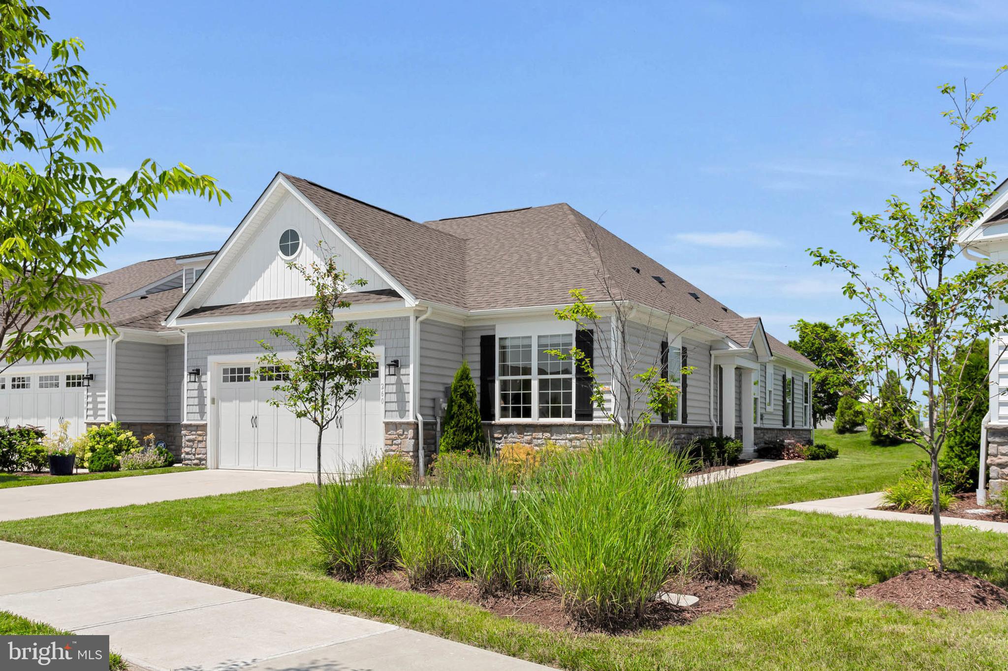 OPEN HOUSE TUES 7/22 4-7pm. Come see this spectacular unit and others in the neighborhood. Welcome to 260 Moorings Circle — where every day feels like a weekend! Located in the sought-after 55+ community of Bay Bridge Cove on Kent Island, this impeccably maintained 2 BR villa offers the low-maintenance lifestyle you’ve been waiting for—just minutes from the Chesapeake Bay and an easy drive to Annapolis.
Step inside to find soaring ceilings, sun-filled living spaces, and an open-concept layout perfect for entertaining or quiet mornings at home. The spacious kitchen features granite countertops, stainless steel appliances, and a large island that flows seamlessly into the dining and living areas. A cozy gas fireplace, wide plank flooring, and designer touches throughout give this home a fresh yet timeless feel.
The main-level primary suite includes a walk-in closet and spa-like bath with dual vanities and a tiled shower. An additional bedroom and full bath offer space for guests, hobbies, or a home office. And don’t miss the private back patio—a peaceful retreat for sipping coffee or enjoying happy hour with friends.
Bay Bridge Cove is known for its friendly neighbors and resort-style amenities, including a clubhouse, fitness center, pool, pickleball court, community garden, and walking trails. Lawn care and snow removal are included, so you can spend more time living and less time maintaining.
If you’re ready for simpler days, beautiful surroundings, and a community that feels like home, 260 Moorings Circle is calling!