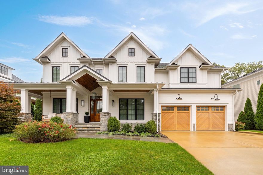 Prominently situated in the heart of coveted Battery Park, 8006 Maple Ridge Road is a stunning modern farmhouse mere blocks from urban Downtown Bethesda. An inviting exterior introduces the home, highlighted by a cozy wraparound front porch lined in Pennsylvania Flagstone. Beneath a towering gable, the large solid wood and glass front door swings open to reveal an elegant foyer. Tall ceilings, artful lighting, wide-plank white oak flooring, and quadruple hinged eight-foot interior doors are a testament to superior quality of construction in which no detail has been overlooked. Off of the foyer, through hidden pocket doors, is a private study, featuring custom built-ins, a herringbone accent wall, and direct access to the porch. The main living area spans nearly the entire floor plan in a true open concept, establishing effortless flow to facilitate both large-scale entertaining and casual contemporary lifestyles. The family room’s floor-to-ceiling stone fireplace and wooden beams overhead add a rustic touch to an otherwise sleek, modern space. A poster child for effective indoor/outdoor living, a stackable glass wall of doors folds away to reveal the stunning screened-in porch, whose electrically retractable screens enable a high degree of flexibility. A roaring wood-burning fireplace, quadruple Bromic heaters, and skylights enable al fresco lounging in all seasons. The kitchen is the heart of the home, with contemporary stacked white Cabico cabinetry complementing white Caeserstone quartz countertops, full-height tiled backsplash, and open shelving. A commercial-grade Wolf Range sits beneath a splendid custom hood, while a paneled SubZero full size refrigerator/freezer, dual Bosch dishwashers, an additional Wolf steam oven, and wine cooler complete the comprehensive appliance suite. The adjacent dining room is topped by a showstopping beamed, shiplap cathedral ceiling and features triple exposures, one of which directly accesses the screened porch. A large mudroom area with dog wash, full bath, walk-in pantry, and extensive custom lockers connects to the oversized, double-height garage. A private office off of the mudroom completes the main level. Ascending the illuminated staircase reveals a stunning primary suite. Automatic shades, a tray ceiling with cove lighting, and a generous dressing room with extensive built-ins further the luxury mission. Likewise, the stunning primary bath is clad in heated porcelain flooring, featuring the ubiquitous dual vanities, separate water closet, elegant freestanding tub, and walk-in steam shower. Three ample additional bedrooms each feature luxuries such as ensuite baths, walk-in closets, and automatic shades, while a large, convenient laundry room with integrated shelving completes the upper level. LVT flooring carries through the lower level, a space characterized by a large open recreation room, sixth full bath, and extensive storage. Out back, the fully fenced rear lawn is level and square, offering usability and privacy accented by a stylish stone retaining wall. Behind the scenes, the very latest in technology runs state-of-the-art systems within the home, including Lutron lighting, Klipsch surround sound, comprehensive security with integrated video surveillance, smart HVAC, tankless water heating, generator pre-wiring, and energy efficient construction. Convenient to shopping, dining, entertainment, parks, and the city while belonging to highly regarded schools, 8006 Maple Ridge Road showcases a new chapter in luxury living.