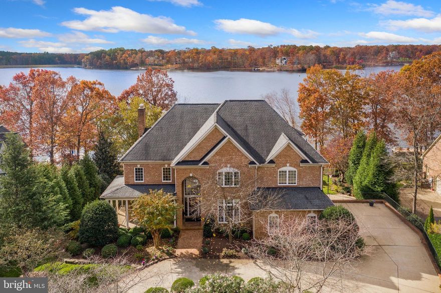 Some say that 10814 Perrin Circle has the best location on Fawn Lake. It is on the "sunny side" of the lake. The home boasts beautiful views of the sunrise, sunset, and the moon at night from multiple vantage points.   Regency Builders custom built this all brick home which is perfectly sited on a premier water front .55 acre lot with 139 feet of shoreline with bulk heading, a private sand beach, plus a maintenance free Trex dock with an electric boat lift. Moor your boat on your private dock, which has a depth of 6 feet. This location offers easy access to the deepest part of the lake.  A circular driveway leads to the gracious entry. The floor plan is airy, easily flowing from one room to the next. There is a stunning two story foyer which has its own custom designed marble motif in the hardwood flooring. Just off the foyer is the open design of the coffered ceiling great room with wood or gas burning fireplace, custom bookcases, and windows expand the entire room with outdoor vistas. The large gourmet eat-in kitchen, a work from home office, and long, wide Trex deck provide views of the lake all year round. There is also a living room, spacious dining room and two powder rooms on this entry level.  The first floor has 10 foot ceilings, 9 feet on the second floor. Hardwood flooring on the main level of this residence. Surround sound inside and out.  The light filled kitchen offers an expansive island, and casual eating space. Designer lighting, granite counter tops, spacious walk through pantry - with large wine storage refrigerator, are only part of this kitchen. It's a cook's kitchen with two Jenn Air wall ovens, Dacor 36 inch, 6 burner gas cook top, two Bosch dishwashers, Uline ice maker, and a Dacor warming drawer.  An elegant spiral stairway leads to the upper level which has an expansive primary bedroom suite with gas fireplace, sitting room, office, his and her walk in closet, plus spacious bath -- all with lake views! The marble bath features a Kohler 8 jet whirlpool soaking tub, three way shower system and double sinks.  Three more bedrooms each with its own bath, plus a large laundry room with built in ironing board complete this upper level. Walk down the back stairway to the large pantry off the kitchen, the two car garage, mud room and powder room.  The sunny walk out lower level has a large family room with fireplace, two more bedrooms - each with a lake view - and baths. Storage rooms, plus an exercise studio complete this floor. Easy access to the lake and outside entertainment area from this walk out level.  A screened gazebo has power, bar refrigerators, water and is adjacent to a grilling station with wood burning fireplace. Steps away your boat awaits you on the lift at your private 600 sq ft Trex dock.   The beautiful landscaped grounds feature a lake-fed underground sprinkler system.  Fawn Lake, spanning over 7 miles of shoreline, affords boating, paddle boarding, kayaking, swimming, and fishing. You have easy water access to the country club restaurant, pool, and deep water  floats.  If you are a golfer the Arnold Palmer-designed 18 hole golf course awaits your tee time.  Family friendly Fawn Lake community offers tennis courts, basketball courts, volleyball courts, pickleball, soccer field, baseball fields, swimming pool and 100 slip marina. Plus walking trails, club house, fitness center, Lakeside Restaurant, Country Club, playgrounds.  Move to 10814 Perrin Circle in family friendly Fawn Lake - an idyllic gated community that has it all! Work from home and have all the amenities just outside your front door. Come experience what the lake lifestyle is all about!