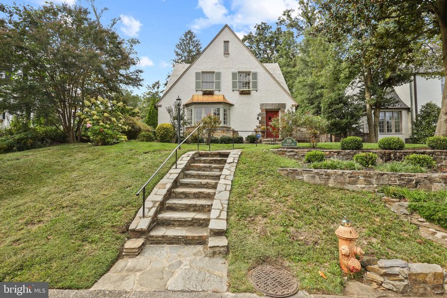 Welcome to this stylish and sophisticated stone and stucco  French style Tudor home featuring  five bedrooms, three full baths, two car detached garage and fenced yard perfectly nestled in coveted Homeland.  This home has been impeccably updated and represents a harmonious blend of timeless charm and modern luxury.  The spacious living room is truly the heart of this home and  features a  glorious wood-burning fireplace with stone surround.  The elegant and generously sized dining room is an entertainer's delight with french doors to the idyllic sun room that opens to the courtyard and patio.  The fully equipped chef's kitchen with granite countertops, Wolf Stove and high end stainless steel appliances, is perfect for the culinary enthusiast. The upper levels feature four spacious bedrooms including the primary suite with a sleek new full bath.    The fifth bedroom and third full bath are found in the completely finished lower level with laundry room,  additional space for a home office,  family room, ample storage, 2020 Boiler and new zoned AC. 
 The enchanting and fully fenced  backyard, features a stone courtyard with built in stone fireplace, and a bucolic garden;  truly an outdoor oasis and the perfect respite to a hectic day.