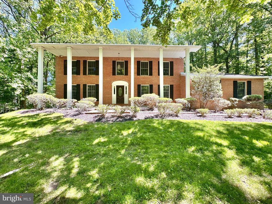 **OPEN HOUSE MAY 17th, 1PM – 3PM** Welcome to this stately brick-front Colonial, beautifully sited on a private 1.64-acre lot backing to mature trees on a quiet no-thru street. A full-length covered front porch with classic columns creates a warm and inviting first impression while the serene setting offers peaceful views, abundant wildlife and a true sense of privacy. Lovingly maintained by its original owner since 1983, this spacious 4-bedroom, 2.5-bath home offers over 4,300 total square feet of living space across three finished levels. Inside you are welcomed by a generously sized foyer with hardwood flooring that continues through the living room, dining room and private office. The expansive living room features a brick wood-burning fireplace, plantation shutters, sconce lighting and crown molding, while the formal dining room is ideal for gatherings with plantation shutters, a statement chandelier, crown, chair and picture molding. A private office with built-ins and French doors to the deck offers a perfect work-from-home or flex space. The traditional floor plan includes an eat-in country kitchen with granite countertops, breakfast bar/peninsula, three pantries and great table space overlooking the backyard. The adjacent family room features a second wood-burning fireplace, new carpet, built-ins and French doors to the deck. A mudroom/laundry room with side entry and garage access adds convenience.
Upstairs are four generously sized bedrooms, including a spacious primary suite with dressing area, additional vanity, dual walk-in closets and private bath with soaking tub and separate shower. The secondary bedrooms offer new carpet, ample closet space and share a hall bath with skylight and dual vanity.
The fully finished walk-out lower level is sure to impress featuring a large recreation room with brand-new carpet, cedar wood walls and built-in bar. Additional space offers storage or future potential, including an area with existing shower and rough-in for a full bath. Outdoor features include a 34’ x 10’ deck, multi-tiered paver patio and landscaped grounds. The former in-ground pool has been professionally filled, creating additional usable yard space. A long driveway leads to an oversized side-load garage. ** Recent updates in 2026 include new carpet, fresh paint, new insulated garage door, new French doors, updated locks, new smoke detectors and landscaping improvements. Major updates include water treatment system (2023), hot water heater (2021), leaf guards (2015) and 50 year architectural roof and HVAC (2010) ** Conveniently located near top-rated schools, shopping, dining and commuter routes including I-83 and I-695, this home offers space, privacy and opportunity—ready for your personal touch. WELCOME HOME!