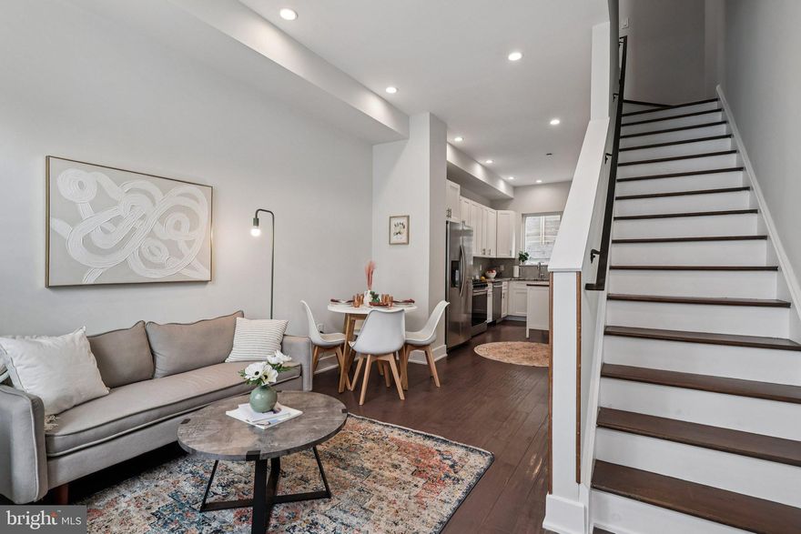 Welcome to 1203 N. Etting Street, a modern 3-bedroom, 2-bathroom townhouse offering over 1,300 sq ft of stylish living space in the heart of Brewerytown. Built in 2019, this home features high ceilings, oversized windows that flood the open-concept main level with natural light, and a designer kitchen equipped with stainless steel appliances, white shaker cabinets, quartz counters, and a custom backsplash. The second floor offers two generously sized bedrooms, a full bathroom with modern finishes, and convenient laundry, while the third floor is dedicated to a private owner’s suite complete with a walk-in closet and spa-inspired bath with dual vanity and glass shower. The fully finished basement provides flexible space for a home office, gym, or media room, and the rooftop deck delivers partial skyline views and an abundance of sunset views—perfect for entertaining or relaxing outdoors. Additional highlights include central air, efficient mechanicals, hardwood floors throughout, and approximately four years remaining on a valuable tax abatement. Ideally located on a quiet block just steps from Girard Avenue, Fairmount Park, and an array of restaurants, breweries, and shops, this home offers the perfect combination of comfort, convenience, and modern city living.