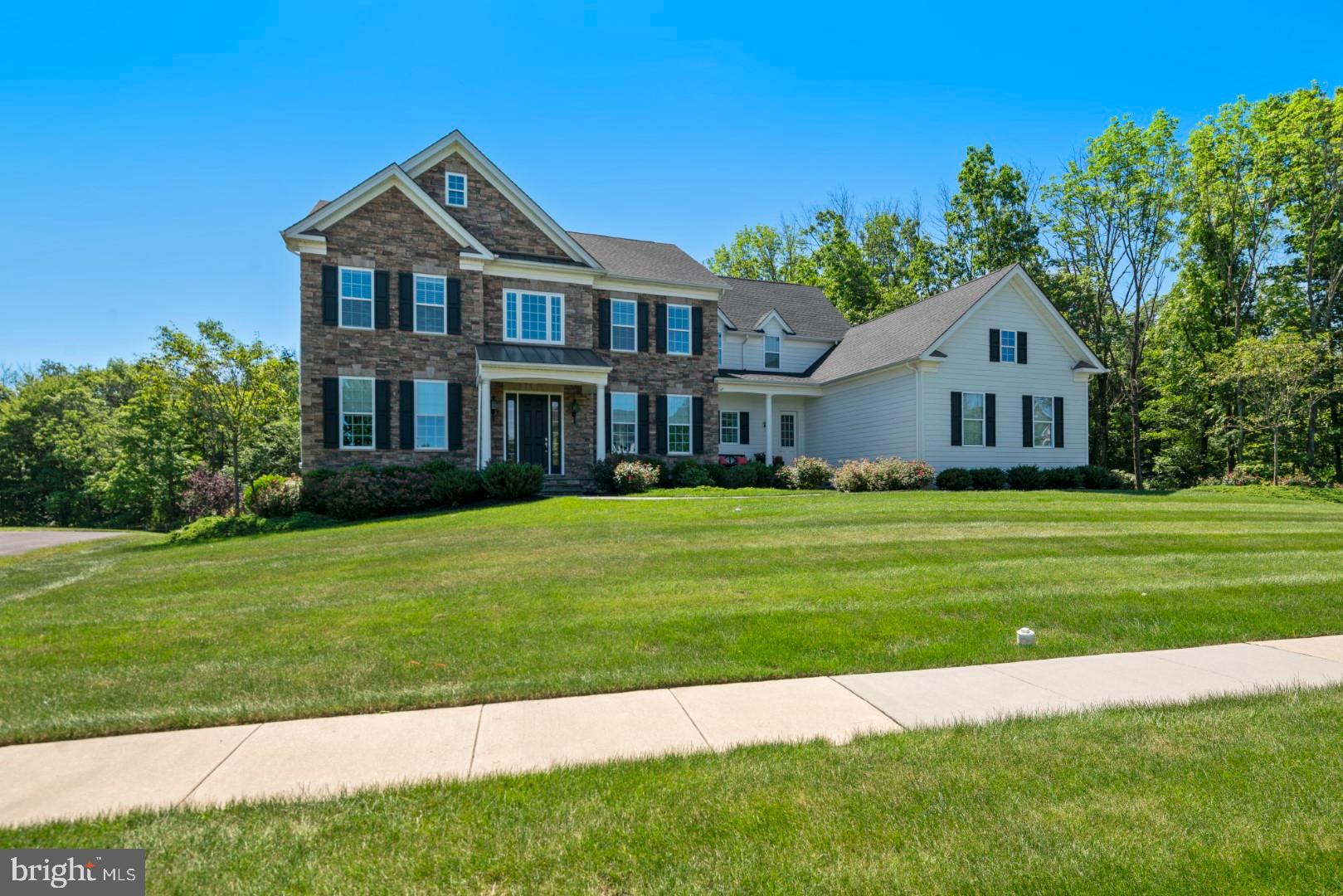In the prestigious community of the Estates at Mill Creek you will find this gorgeous custom home on a premium lot that offers amazing privacy backing to woods and adjacent to dedicated open space. The two-story foyer is complimented by an elegantly curved staircase and leads to the spacious formal living & gracious dining rooms in addition to a private study. Soaring 10-foot ceilings, double wide crown molding, walnut hardwood floors and rich millwork are found throughout. Sophisticated pillars frame the sunken gathering room, with grand stone gas fireplace and floor-to-ceiling windows and doors, that lead out to a maintenance free composite deck overlooking the private rear grounds. The home flows into an expansive open concept gourmet kitchen that is sure to WOW. Equipped with sleek granite countertops, a Viking 6 burner range with griddle, custom cabinets, marble subway backsplash and a suite of high-end stainless-steel appliances. A massive eat in center island offers additional seating and a centerpiece for entertaining. A breakfast room sits adjacent, boasting a sun-drenched space to enjoy a morning cup of coffee while enjoying peaceful treetop views. A convenient mudroom and two half baths complete this level. Heading upstairs by either staircase 4 bedrooms each have a dedicated full bathroom. The master's is rightfully the most luxurious with a tray ceiling, private sitting room and spacious dual walk in closets. The master bath is ready to destress and pamper with a frameless shower, spa soaking tub and natural travertine tile. A substantial walk out lower level offers endless possibilities. Enjoy the picturesque setting on cool summer evenings on the bluestone patio nestled around the custom firepit overlooking a tranquil pond with cascading waterfall. The multi-level professional landscaping features a winding stone stairway and path that leads to the patio overlooking this amazing setting. Additional amenities include a 3-car garage, whole house generator, beautiful neutral color palette and conveniently located within Central Bucks schools.