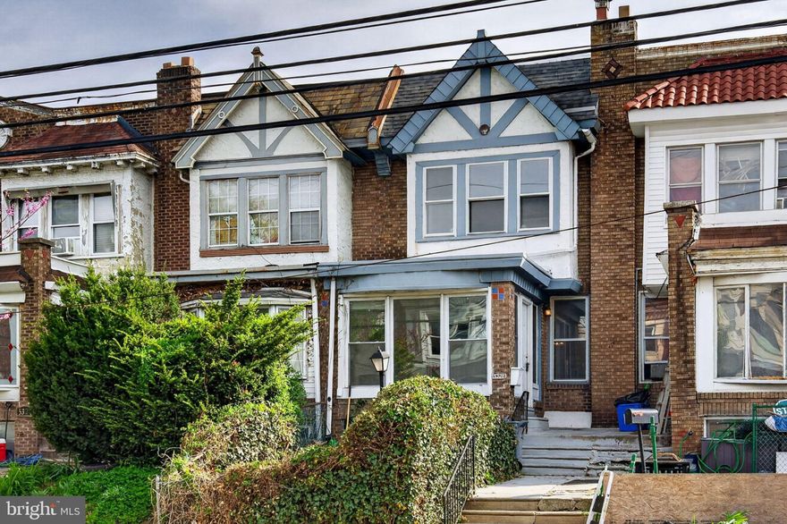 Welcome to 5328 Locust Street, this wide and airy West Philly rowhome has it all: cohesive design, original beauty, space to grow with 3 beds, 1.5 baths over 1600sqft, and most importantly, parking.
The first floor starts with drama: a herringbone-tiled sunroom with floor-to-ceiling windows and French doors that open into a large straight-through floor plan. Original white pine floors with a cherry inlaid border immediately catch your eye upon entry and continue through the whole house. The living room features white exposed brick and a decorative fireplace, and the dinning room continues the unique details with its original mirrored corner doors -- one to a coat closet and the other down to the finished basement, half bath, and laundry area. The kitchen accents include modern cabinetry, a deep undermount sink, new stove, pantry, and the return of the herringbone tile! Following the original oak stair treads to the 2nd floor, you'll find three bright and spacious bedrooms, each with its own deep closet.
The front primary bedroom has a large trio of windows, a brick accent wall, and a large radiator for cats and plants. The middle bedroom connects to the rear bedroom, great for nursery, guest rooms and offices. The hall bathroom features a soaking tub, vaulted ceiling with a skylight, and a linen closet. 
The finished basement has access to a full-size garage with EV charger and the back alleyway, making the space perfect for storage or even a workshop. The house also has a balcony off the kitchen that combined with the hedge-lined green space in the front makes it a true gardener's or hobbyist's delight!
Beyond the house itself is the community feel of the block with tight-knit neighbors, proximity to the Market Frankford Line and Baltimore Ave trolly, neighborhood staples like the Lucien E Blackwell Library, the YMCA, Malcolm X Park, and the 52nd street commercial corridor, which boasts events such as Urban Arts Fest. Come see it for yourself!