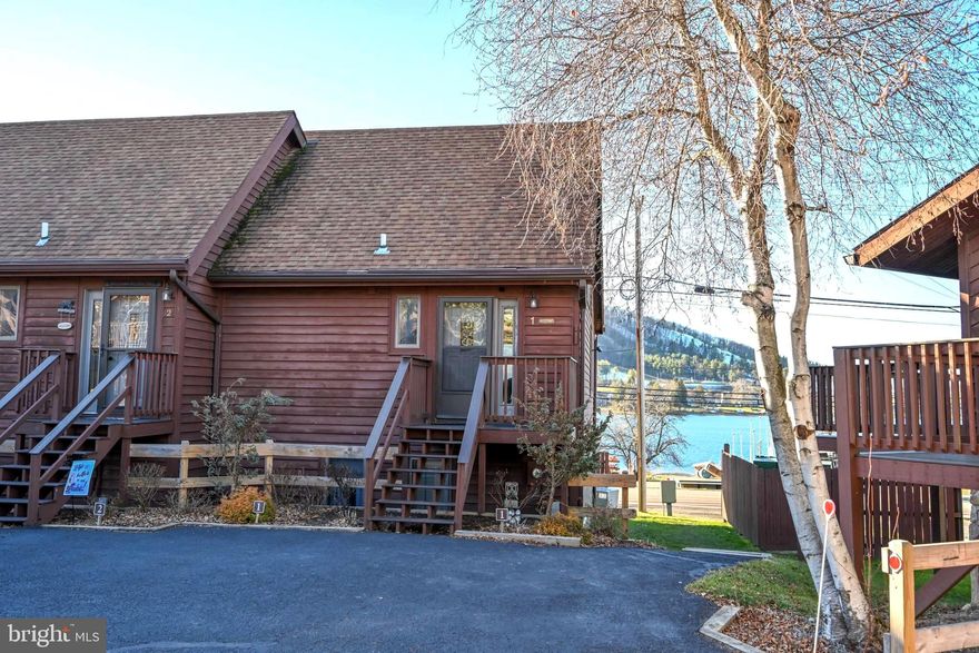 Your affordable Deep Creek Lake lakefront oasis awaits!  Take in the stunning lake and ski slope views as soon as you walk in the door.  This charming lakefront, 3 bedroom 2 1/2 bath end unit condo is ready for you to enjoy! Vaulted beamed wood ceilings and a stone fireplace add to the beautiful ambiance.   A very spacious loft overlooks the living/dining/kitchen area. A half bath completes the first floor.  The lower level roomy primary bedroom and bath leads out to a private deck with the lake just steps away!  2 charming bedrooms and a second full bath complete the lower level. This condo has room for everyone!  The community of Sunplace offers a private level lakefront area just across the street.  The community building is next door with an indoor pool and community room!  Just minutes away from Wisp Ski area, 2 golf courses, the Wisp Mountain Coaster, ASCI Whitewater Park, Monkey Business Adventure Park, multiple restaurants and shopping!  The location could not be better.  Enjoy the sunset on your private balcony overlooking the beauty of Deep Creek Lake.  In the winter, sit by the fire and look at the lights of Wisp.  Make your appointment today to preview this wonderful property, and begin the relaxation and joy!