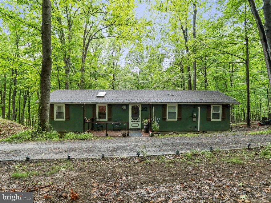 Escape to your peaceful retreat with this well-maintained 3-bedroom, 1-bath rancher set on 2  wooded acres of land! Enjoy a partial mountain view and the tranquility of nature from the comfort of your home. Inside, you'll find durable LVP flooring throughout, a spacious family room, a dining area, and a functional kitchen ready for your personal touch. Enjoy year-round comfort with a newer Mitsubishi mini-split system for heating and cooling. A UV purification system ensures clean, safe well water. The property includes three outbuildings -- a versatile 12x24 detached garage with electric, perfect to park your car, use for storage, or use as a workshop. An 8x12 shed for additional storage or hobbies, and a compact 3x3x7 tool shed for gardening or outdoor equipment. As part of an HOA, you'll have access to a small scenic lake with a beach area—perfect for relaxing summer days. Located just minutes from Cacapon State Park, you'll have easy access to hiking, fishing, and outdoor recreation year-round. Whether you're looking for a full-time residence or a weekend getaway, this home offers the perfect blend of comfort, privacy, and natural beauty. Schedule your showing today!