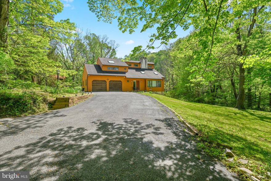 Private Contemporary Home on 1.9 Acres in Pennsbury Township – Unionville-Chadds Ford Schools! Tucked away on 1.9 acres and surrounded by woods and a peaceful stream, this custom-built contemporary offers a quiet, nature-filled setting right next to Longwood Gardens. With 3 bedrooms and 2.5 baths, it’s the perfect place to relax and make your own. Step inside to a bright, open two-story foyer that leads into a large living room with vaulted ceilings, skylights, and a stunning floor-to-ceiling stone fireplace. Big windows bring in an abundance of natural light offering beautiful views of the surrounding property. The kitchen includes a cozy breakfast area and sliding doors to the backyard—ideal for adding a deck in the future. It flows easily into a sunny dining room that’s great for gatherings. The main floor also has a powder room and access to the oversized two-car garage. Upstairs, the primary bedroom features a cathedral ceiling with skylights, a walk-in closet, and its own private bath. Two additional bedrooms and a full bath overlook the living room below, adding to the open feel of the home. The walk-out lower level has a brick fireplace and plenty of potential to finish however you’d like, plus easy access to the side yard. Set on a shared private lane with just one other home; you’ll enjoy a tucked-away feel while still being close to major routes, shopping, and restaurants. Ready for its next owner to add personal touches and make it shine—being sold as-is.