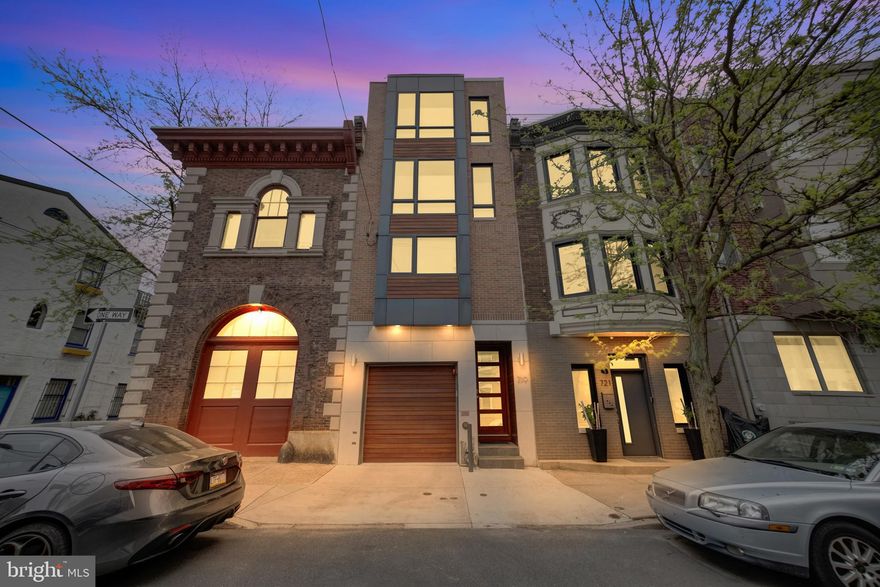 A masterpiece of design and location, in the heart of Graduate Hospital with Garage parking & ELEVATOR, this 4-story townhome (built in 2017) is a dream for the most discerning buyers. Exuding elegance from the gorgeous façade to the Azek vinyl roof deck atop a TPO roof, this property is sure to please. Enter this sleek home into the vestibule, which features natural, unpolished stone tile flooring connecting directly to the 1 car garage. Beyond the tile and throughout the home you will notice rich 7” wide-plank natural oak engineered flooring. This first level offers a private guest room and/or home office w/ closet and features a full bath with natural tumbled travertine, a custom shower stall and vanity plus access to the magnificent patio with stone pavers. This private patio is one of 3 outdoor spaces and offers an escape from the city with a dreamy whirlpool, perfect place for relaxation after a long day. Take the custom stainless steel and open tread oak staircase or the private elevator to all levels of the home. Just one level up and you’ll be in the home’s main living area. A comfortable living room awaits, featuring a modern gas fireplace with glass beads, a ledge stone accent wall, a ceiling fan and both recessed and accent lighting.  Double sliding glass doors provide access to a vinyl deck, perfect for grill (with built-in gas line) and al-fresco dining. Back inside you will notice a convenient bar with Caesarstone Quartz counters, wine refrigerator and storage between the living and dining areas. The gourmet kitchen features rich wooden cabinetry from Society Hill Kitchens & Custom Interiors and Thermador stainless steel appliances including a French door refrigerator, range hood, cooktop, dishwasher, and a combination convection/standard/microwave oven. The matte finished Caesarstone Quartz countertops, backsplash and waterfall offer a lovely contrast with the cabinetry. Enjoy countertop meals at the convenient breakfast bar, or at the dining area just off the kitchen. There is also a convenient powder room with a slate accent wall and floating walnut countertop with hammered vessel sink on this level. The third level of this home features two spacious bedrooms, each with oversized windows and custom closets. A shared hall bathroom plus a laundry room with basin are also located on this floor. The bathroom offers neutral gray tumbled travertine tile in herring bone pattern, Caesarstone Quartz countertop, and a tub/shower combo with glass door and Grohe polished chrome fixtures. The entire 4th floor primary bedroom suite offers an oversized bath along with two walk-in closets, a third storage closet and a westward facing floor-to-ceiling window wall. Enjoy your extra deep soaking tub, a double vanity with natural stone and ceramic accent wall plus luxurious walk-in shower, complete with body jets and stone bench. Up one more flight of stairs to access the roof-deck, which offers unobstructed city views and a fantastic entertaining space. Don’t miss the fully finished (with legal egress) lower level with wet bar and beverage center, that offers extra flex living space. Every detail and finish in this home exceeds expectations, including the digital front door, Emtek hardware, video intercom, Honeywell alarm system as well as the full house sprinkler system and 2 high efficiency HVAC systems. Located just South of South Street, you’ll enjoy easy access to excellent restaurants, shops and groceries along the corridor, or take a short stroll to Rittenhouse or Fitler Square. A quick bike ride, Uber or easy public transportation takes you to CHOP, University of Penn or Drexel University. All this and approximately 4 years remain on the tax abatement!