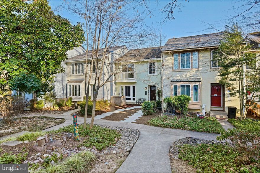 Enjoy sweeping Lake Thoreau views from all three levels of this waterfront townhome, with direct access to Reston’s largest lake and a private waterfront mooring. Outdoor living shines here: a large Trex deck overlooks the water and leads via stairs to a professionally landscaped backyard with native plantings, wired landscape lighting, and hand-stacked flagstone retaining walls. A dedicated GFCI outlet near the water makes lakeside entertaining and water activities easy, while the patio and rear yard offer a peaceful setting just steps from the shoreline.
Inside, the main living level is designed to maximize the views. A contemporary ProVia Signet fiberglass front door with 3-lite glass opens to a tiled foyer and an updated powder room with a floating walnut vanity and shelving that convey. Ceramic tile continues through the breakfast area and into the well-appointed kitchen featuring soapstone countertops, KraftMaid cabinetry with soft-close drawers, a Maytag 5-burner electric range, stainless built-in microwave, Maytag dishwasher, and KitchenAid French-door refrigerator. Through an arched opening, the dining and family rooms showcase expansive lake views, sand-in-place hardwood floors, and a corner wood-burning fireplace with dual exposure. Updated sliding glass doors from both rooms open directly to the deck.
The upper level offers a hardwood landing, three bedrooms, a linen closet, and a newly renovated hall bath. The primary suite captures serene lake views and includes an updated bath with a mirrored sliding barn door, custom cherry vanity by Virginia Hardwood Artisans, frameless shower, private commode area, and premium whisper exhaust fan with heater. The lower level features luxury vinyl tile flooring, a spacious recreation room with sliding glass doors to the patio and yard, a full hall bath, and a fourth bedroom with tranquil water views. An unfinished storage area houses the Whirlpool washer, GE dryer, Carrier heat pump furnace (2013), and 50-gallon AO Smith water heater (2014). The exceptional location places you just a short walk to South Lakes Village Center and provides direct access to Reston’s 55-mile trail network, perfect for walking, kayaking, paddleboarding, and fishing.