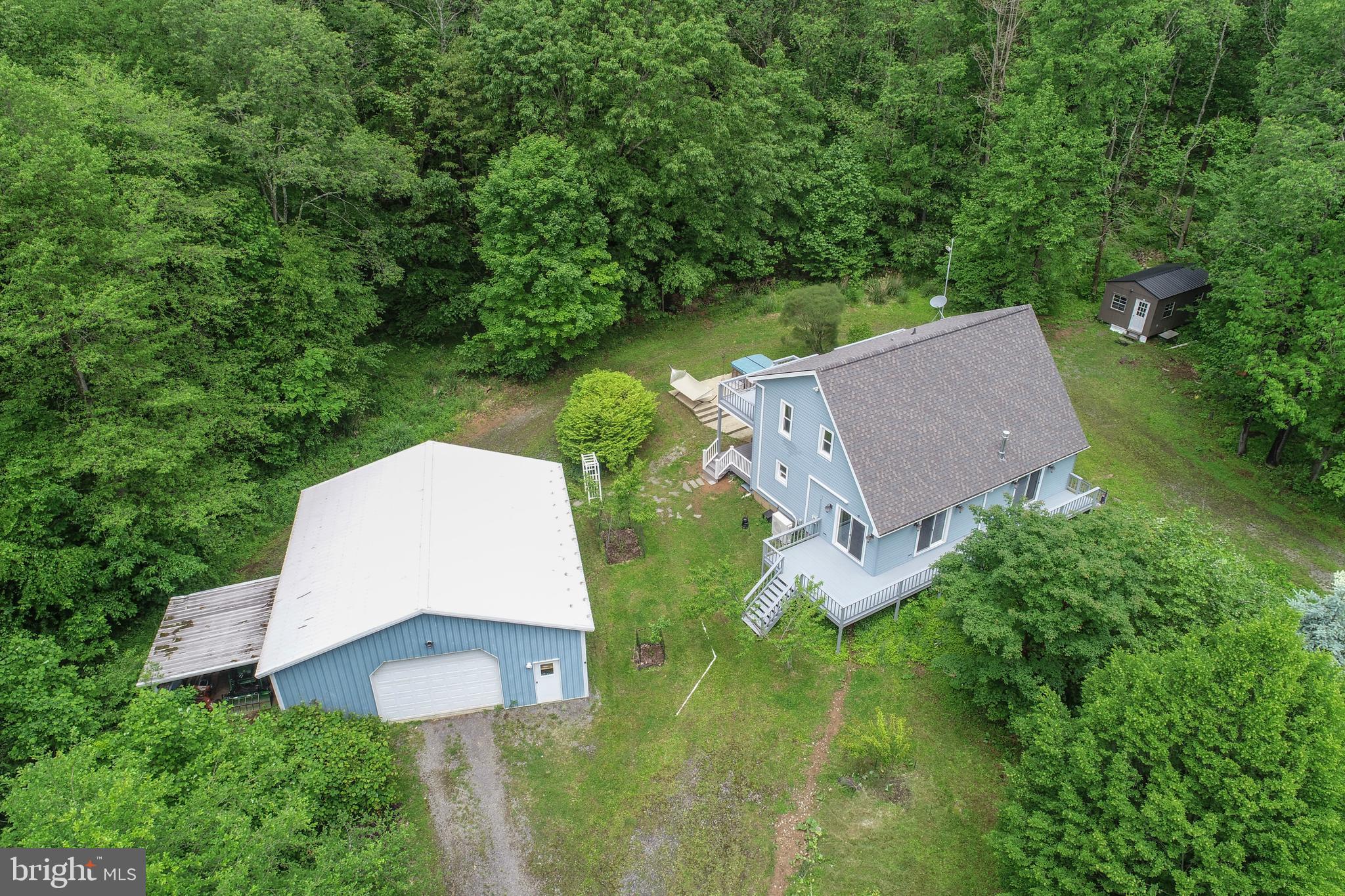 Tucked away on 5 private acres, this charming 3 bedroom, 2 bath cabin-style home offers the perfect blend of rustic retreat and modern convenience. Recent exterior updates enhance the home’s curb appeal, and a brand new deck provides the ideal space for outdoor relaxation. Enjoy the peaceful wooded setting with a flat, grassy yard—perfect for play or gardening—and unwind in the hot tub under the stars. The oversized detached garage offers ample room for vehicles, equipment, or workshop space, while an additional shed/shop provides even more storage or hobby potential. With two finished levels, this cozy mountain getaway is functional and flexible for full-time living or a vacation escape. For those looking to expand, an additional 12-acre parcel is available right next door, offering endless potential for privacy, recreation, or future development. Whether you're seeking serenity or space to grow, this property is a rare find in a beautiful wooded setting. Just minutes to Deep Creek Lake, Wisp Resort, and all area amenities & attractions!