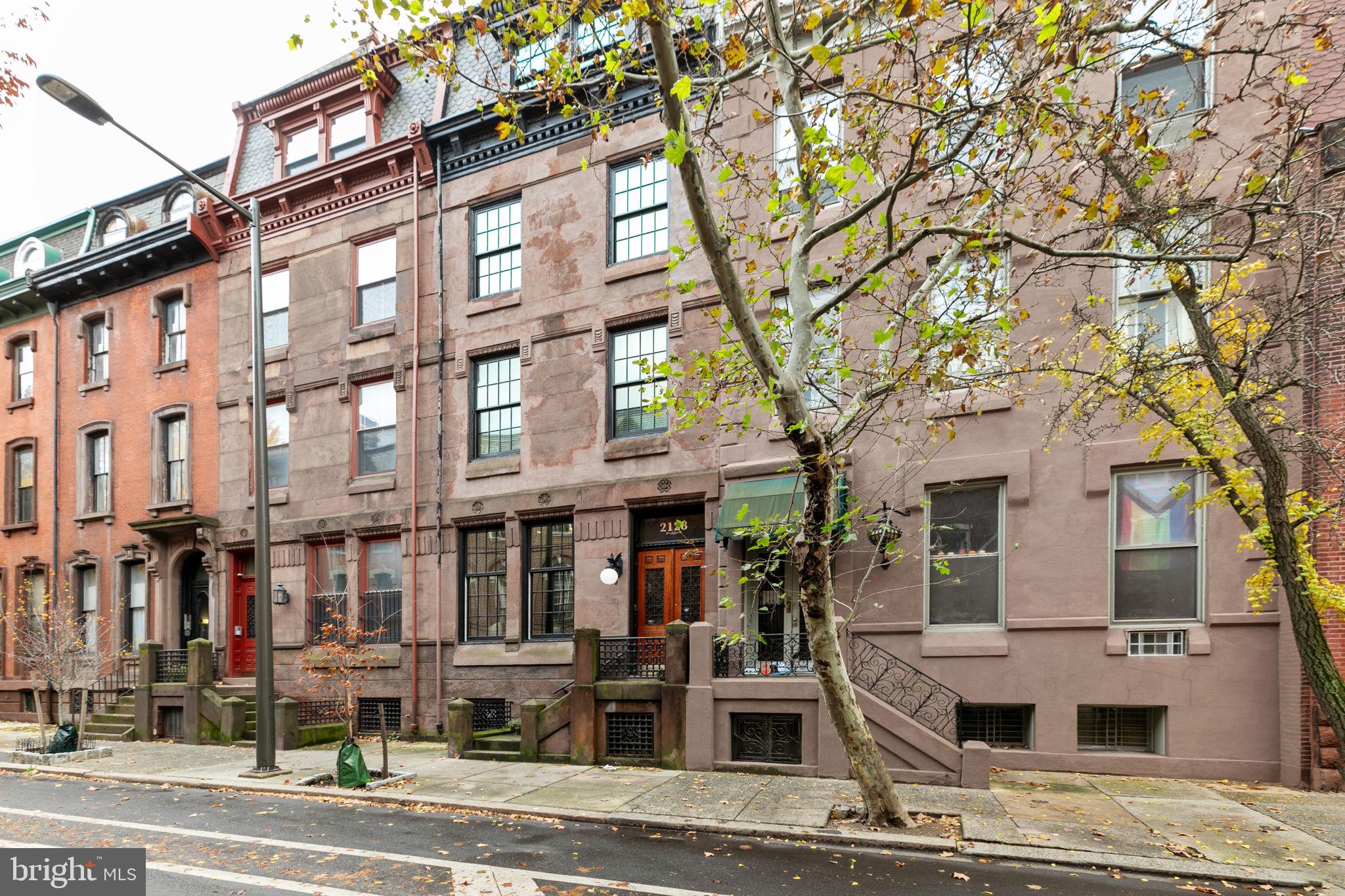 Welcome to 2128 Spruce Street in Fitler Square! This stately, modernized 5-bedroom townhouse sits 20 ft wide on a 105 ft lot with high ceilings, hardwood flooring, and original details. Enter through the vestibule into a spacious, light-filled living room with 12 ft ceilings and a sleek contemporary fireplace. Just off the living area are a discreetly located powder room & two large coat closets. The eat-in kitchen is also on the main level and features a large chef's island with butcher block countertops, maple cabinets with stainless steel counters, and stainless appliances. The dining area is open to the kitchen with a wood-burning stove, and south-facing windows overlook the spacious back terrace.
A charming center staircase takes you up to the next level of this home, which is equally as grand with a handsome library in the rear that features a fireplace and beautiful built-in bookshelves, a full bathroom with a shower and pedestal sink that has access from the hall as well as the library. An elegant primary suite completes the 2nd level with a fireplace and built-ins. It features an en-suite dressing room with a walk-in closet and a contemporary bathroom with a seamless glass shower, soaking tub, mosaic tile flooring, and an oversized single vanity sink. Two guest rooms with a hall bathroom plus a home office and a laundry room are located on the 3rd level, with two additional bedrooms (one is used as a home gym) and a hall bathroom on the 4th level.
The garden level features a full studio with direct access to the back terrace. This space is perfect for a home gym, guest suite, artist studio, rec room, or play space.
Located in the Greenfield School catchment, this property is situated between Fitler Square Park and Rittenhouse Square. It offers easy access to the Schuylkill River park and trails, 30th Street Station, Penn, CHOP, and Drexel, and nearby neighborhood favorites, restaurants, and retail.
Seller is offering 1-year prepaid parking at a nearby parking facility.