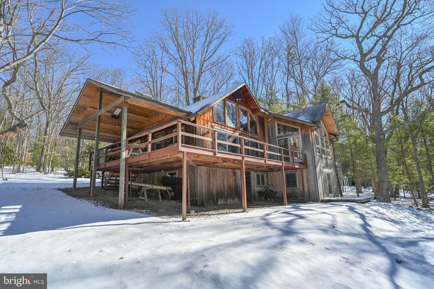 Deep Creek Lodge in Thousand Acres Lake and Golf Community. Southwestern exposure on 100' of gently sloped lakefront with an open floor plan. Massive native stone wood burning fireplace to knock the chill off year-round.  No shortage of natural light with a wall of glass overlooking the lake.  Large lakeside deck 
 that's partially covered is a great place to enjoy being outside, rain or shine. Minutes away is the Thousand Acres Golf Course. Across the street, a wooded one-acre lot is included for a total of two-acres in all.  A must see for those who prefer a private lodge style rustic lake life escape.