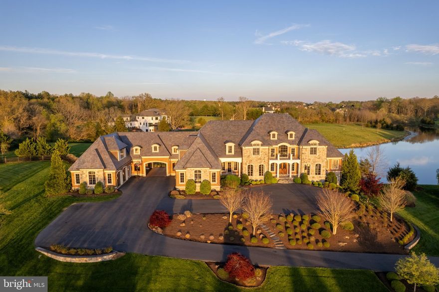 Step into the pinnacle of luxury living at The Estates at Creighton Farms, where exclusivity meets elegance. Situated on a premium 3.3-acre lot with breathtaking views, this architectural masterpiece is a testament to refined craftsmanship. A 24/7 manned, gated entrance ensures unparalleled privacy, while the distinguished brick and stone exterior by Creighton Enterprises Custom Homes exudes enduring quality and sophistication.

Inside, every detail has been meticulously designed, from the energy-efficient 5-zone geothermal system and slate roof to Anderson windows, copper gutters, a Generac generator, central vacuum, elevator shaft, and a 4,000+ sqft walk-up attic for storage. The 6-car garage is an auto enthusiast’s dream, featuring high ceilings, Tesla chargers, epoxy floors, and overhead storage racks, plus a porte-cochere with additional covered parking.

Entertain effortlessly in the outdoor oasis, where an infinity-edge saltwater pool, poolside kitchen and bar, two outdoor fireplaces, a fire pit, and an eight-person hot tub create a resort-like retreat. A private dock on Creighton Farms' largest body of water—stocked with bass and bluegill—offers endless enjoyment.

The grand two-story foyer with dual floating staircases welcomes you into a home designed for both grandeur and comfort. The formal dining and living rooms, sunroom, and library showcase stunning water views. The great room boasts soaring coffered ceilings and direct deck access, while the chef’s kitchen—appointed with Thermador, Wolf, and SubZero appliances—is a culinary haven. A patio room extends the living space seamlessly outdoors, while a thoughtfully designed mudroom features personal storage lockers.

The primary suite is a sanctuary with a gas fireplace, covered balcony, and spa-like ensuite featuring heated marble floors, a dual steam shower, soaking tub, and a custom walk-in closet and dressing room. Four additional ensuite bedrooms—three with balcony access—ensure every family member enjoys unparalleled comfort and privacy.

The lower level is designed for recreation, featuring a step-down bar, theatre room, billiards room, and a golf simulator. A fully equipped gym overlooks water views on three sides, while a four-sided concrete walk-in safe with a 1,000-lb. door provides peace of mind.

For extended family or guests, the private in-law/nanny suite above the garage offers a full kitchen and separate entrance, ensuring ultimate convenience and independence.

Welcome home—where luxury, privacy, and timeless elegance converge.