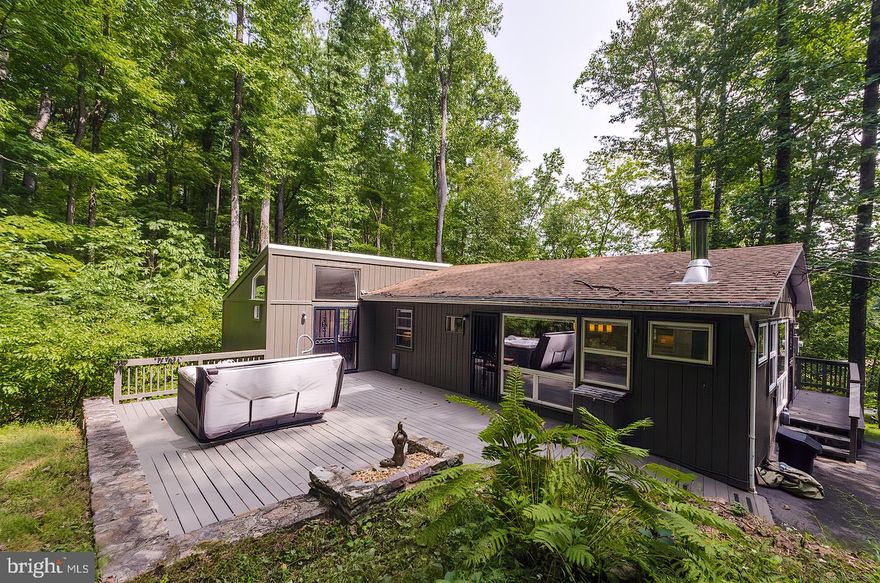 Perfect Get-A-Way, near Berkeley Springs and the newly reopening Coolfont Resort, Easley accessible but private. 2 lots totaling 3.81 aces making a great investment for time. Recently updated in design, flooring paint, cabinets and granite counters, Open great room design with wood stove.  New hot tub for the ultimate in relaxation. This 2 bedroom 2 bath is ready to enjoy! large rear deck with built in stone charcoal grill, Screen porch for that evening game of cards. Fully furnished . Come out and see all the special features this cabin has to offer, but don't wait too long.