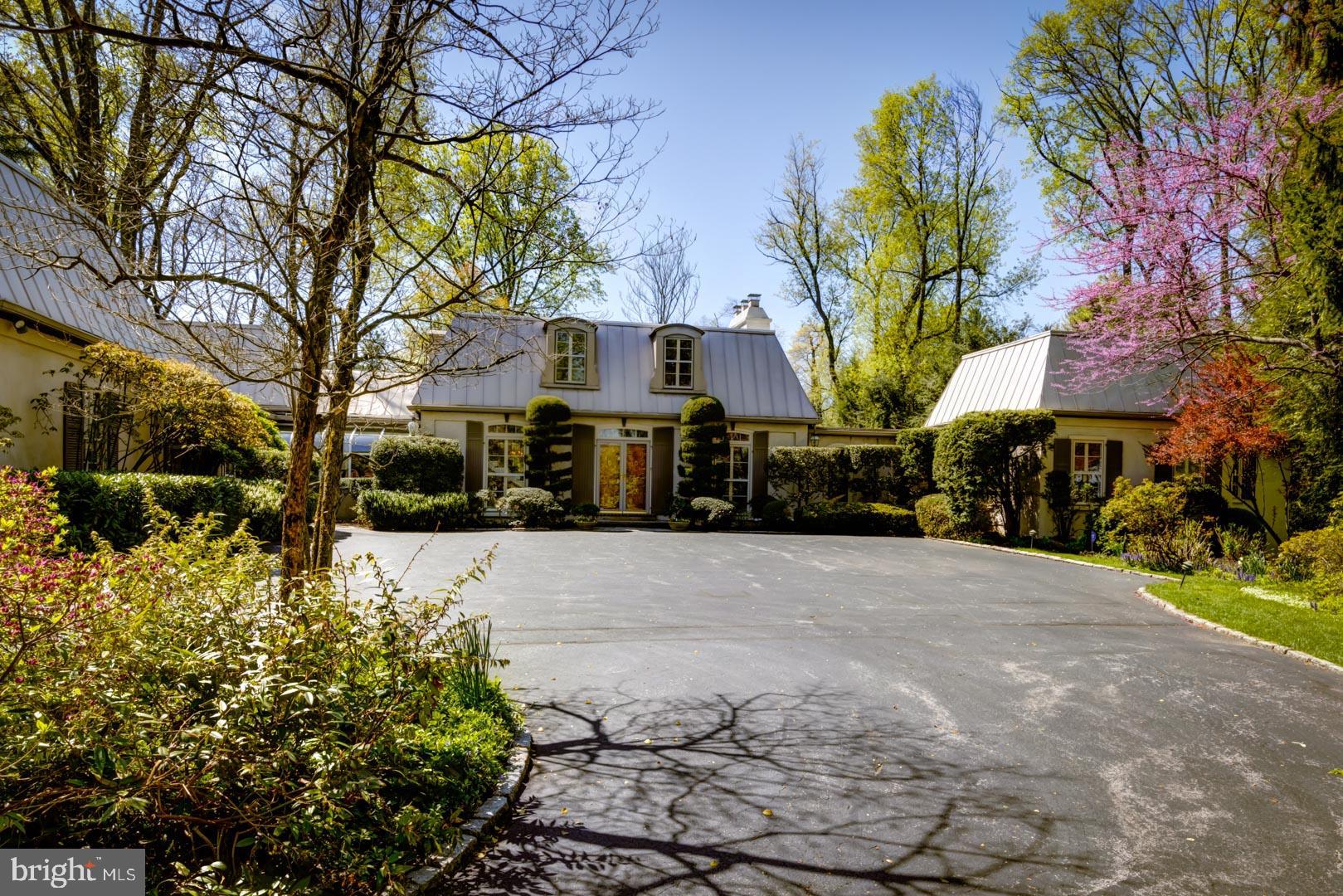 Gracious, custom-built French Second Empire inspired Contemporary in a most desirable location. Spectacular, private 1.3 acre lot with landscape architecture that rivals Longwood Gardens. Blooming shrubs, specimen trees, and green lawns surround a sparkling in-ground pool and large, flagstone patio. Guests and family are welcomed into the lovely foyer with marble floors and an impressive floating staircase. The foyer opens to a spacious dining room and huge formal living room featuring a gas fireplace with marble surround and large windows showcasing the sylvan backyard. The fabulous family room features soaring ceilings, bar area, and gas fireplace with large sliding doors to the yard and patio. A handsome office with built-in cabinetry, shelving and a gas fireplace offers seclusion for work-at-home days and an inspiring view of the yard and pool. The kitchen, featuring an island with seating, stainless appliances and a vaulted ceiling with skylight, opens to a sun-drenched breakfast room. The sizeable first floor owners suite features dual private baths, abundant dressing and custom closet space, and a large bedroom with built-in cabinets and vaulted ceiling. Two guest bedrooms, each with an en-suite bath, are conveniently located on the first floor, with a unique configuration that provides privacy for guests and family. Large laundry room with outside access and an oversized, 3-car garage complete the main level. The second floor features two additional guest bedrooms, each with an en-suite bath. One of the guest bedrooms features a dressing room and sliding doors to a private porch overlooking the backyard and pool. A finished, walk-out basement with half bath adds over 1100 SqFt of living space and is limited only by your imagination. Prestigious location, with award winning Lower Merion schools and convenient access to major roadways and all the amenities the Main Line has to offer. An elegant home and a truly special property.