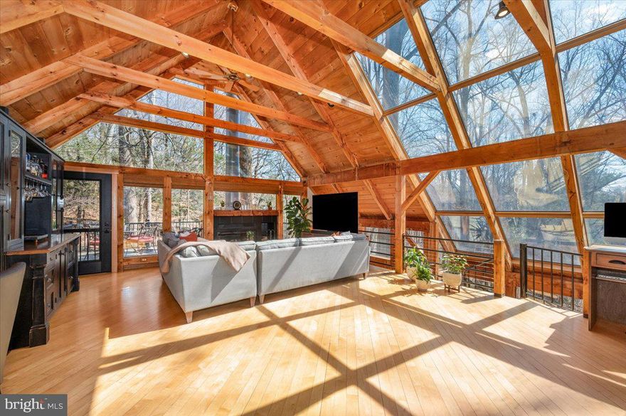 Tucked into the trees on a secluded acre in Cockeysville, this one-of-a-kind timber frame home feels like a private retreat suspended in nature.

Your approach sets the tone. A stone patio leads to a newly built bridge walkway, guiding you to an entrance that opens into a breathtaking, light-filled living space. Warm post-and-beam construction will catch your eye first, while an entire wall of south-facing glass blurs the line between indoors and out. Overhead, expansive roof panels fill the space with natural light, all beneath a classic wood shake roof that complements the home’s natural surroundings.

The main level is designed to be both striking and functional, anchored by a 48-inch Wolf dual fuel professional range that serves as the centerpiece of the kitchen. Soapstone and warm wood countertops, along with a built-in dry bar featuring two refrigerator drawers, make the space as practical as it is inviting. A wood-burning fireplace adds to the ambiance, while a brand-new deck extends your living space into the surrounding trees.

The home unfolds across multiple levels, each thoughtfully connected by a stunning spiral staircase, surrounded by natural light and glass. Every bedroom features its own private deck, offering a rare sense of personal outdoor space for each occupant. On the middle level, a glass-wrapped sitting area creates a sun-drenched retreat between bedrooms, perfect for quiet mornings or unwinding at the end of the day. Even the lowest level is filled with light thanks to the home’s unique positioning on the lot.

Beyond its architectural appeal, this home has been extensively upgraded with over $119,000 in improvements. Major updates include a new energy-efficient HVAC system, a brand-new ductless mini-split on the main level, all-new decks and exterior walkways, six new exterior doors with screens, upgraded electrical with a new panel and whole-home surge protection, new plumbing and water systems including a fiberglass water heater, and a brand-new septic system. Every improvement was made to enhance both the integrity and longevity of the home while preserving its distinctive character.

Homes like this rarely come to market, especially in this location. If you’ve been searching for something truly different, something that feels like an experience every time you walk through the door, this is it.