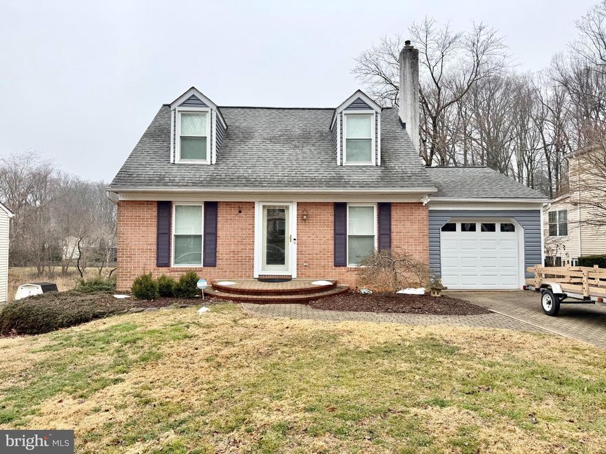 Charming 3BR/2BA Cape Cod with a 1-car garage in the Laurel Valley neighborhood featuring hardwood floors throughout the living room, dining room, and kitchen. The living room offers crown molding and a cozy pellet stove, while the dining room provides access to the garage and a slider to the spacious 24’ x 12’ deck overlooking the rear yard. The kitchen is updated with granite countertops, stainless steel appliances, and a brand new stove and microwave. A main-level bedroom includes an attached full bath with a walk-in shower, offering great convenience and flexibility. Upstairs you’ll find two additional generously sized bedrooms and a second full bath with a new tub. The walk-out lower level is unfinished and ready for your personal touches—perfect for future living space, storage, or a workshop. Updates include deck refinished in 2026; roof, windows and siding new in 2022; and gutters new in 2019.