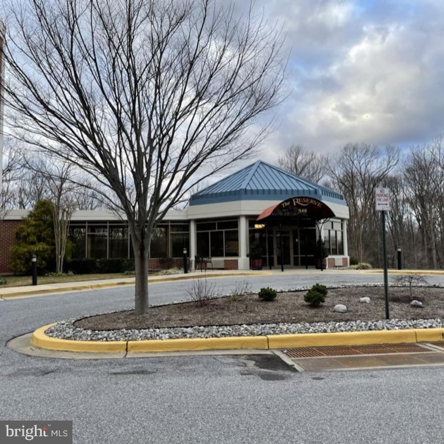 Centrally located within an elegant building, this lovely condo has gorgeous tree-top views! An open floor plan encompasses a spacious dining room,  bright living room, and a large sunroom. The welcoming kitchen has it all: granite counters, beautiful cabinetry, gleaming appliances and a space for bar stools with your morning coffee. The tranquility of the primary bedroom is enhanced by two walk-in closets, a dressing area, and the enticing en-suite bathroom.  On the other side of the condo, you will find the second bedroom with a wooded view, and a full bathroom adjoining the laundry area.  So much to offer, including 7 closets, extra storage in the garage, deeded parking space, and a thriving community with incredible amenities! They include a community lodge, fitness center, indoor and outdoor pools, billiard room, woodworking shop, a library, gift shop, activities room (pickle ball!),  and many meeting rooms to accommodate a variety of social groups. For the outdoor enthusiasts, there is access to the South River, with a dock and kayak racks, walking trails, a lake, tennis courts, and even a golf course! Enjoy a nice meal in our cozy restaurant. Close to historic Annapolis and the Naval Academy, this is care-free adult living at its finest! Buyers pay a one-time fee of $2,075. This property is being sold "as is" and won't be available for very long! Photos are coming soon.