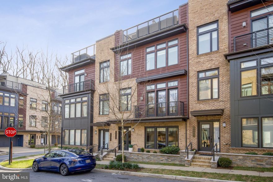 This 5-year-old elevator EYA-built townhome, in Bethesda's Grosvenor Heights community, offers expansive, sunlit living space on 4 levels .... and is the ultimate answer if you're looking to downsize, rightsize or just enjoy low-maintenance luxury living. Presented in pristine condition with owner upgrades, this Cameron model home provides more space than many single-family homes, and even the end townhomes in the community. Ten foot ceilings, walls of large windows, balconies, a 980-square foot roof deck, quartz countertops, Thermador appliances, open stairwells, designer lighting and fixtures, and large walk-in closets - combine to make this is an outstanding residence. Enjoy the best floor plan in the community, a gorgeous open kitchen with generous center isle, a large family room with fireplace and balcony, and a separate dining room. The luxurious primary bedroom suite offers a beautiful ensuite bath and walk-in closet. A separate laundry room is on the bedroom level, along with 2 additional bedrooms. The sensational roof deck offers many owner upgrades including Italian porcelain plank flooring, a full bar with television and a stone fireplace, and sweeping views, for the best in entertaining under the sky! A suite for guests with bedroom, kitchenette, bath, full closet and sitting room (or home office), is included, giving the house a full 4 bedrooms and 3.5 baths. Pull into the spotless 2-car garage to access the house and use the elevator; your guests can park easily in the front. Given its amenities and ideal location near shops, Metro, restaurants, hiking trails and award-wining schools - this truly is your best choice in today's market. Come and see!