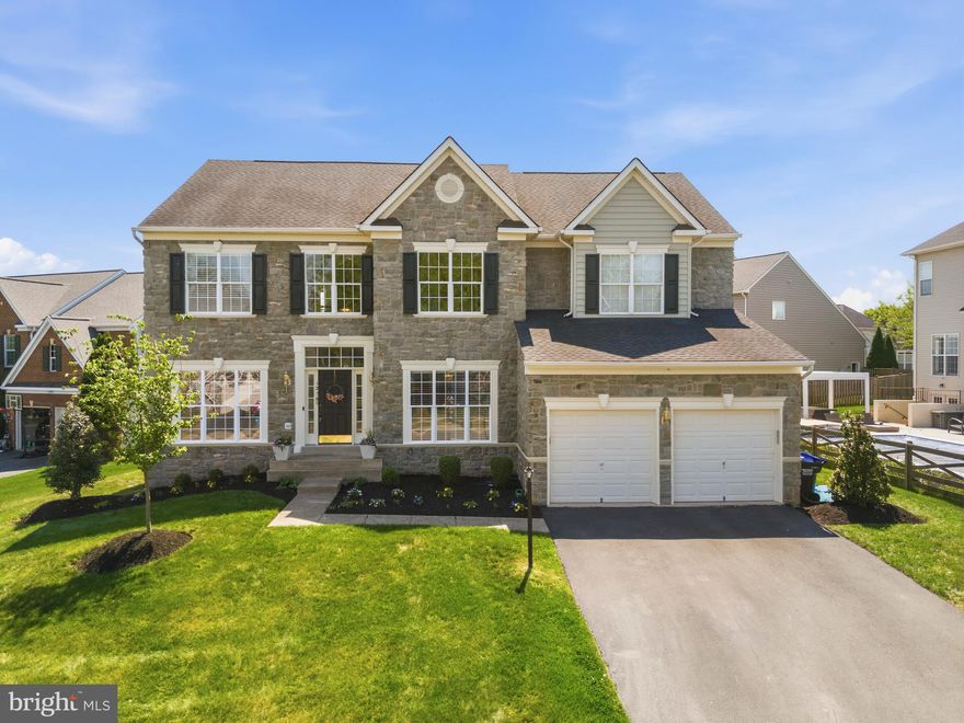 Gracefully positioned on a premium lot in a private cul-de-sac, this stone-front estate offers over 5,200 square feet of sophisticated living space across three beautifully finished levels. Soaring 9- and 10-foot ceilings create an atmosphere of grandeur, light, and architectural elegance throughout.

Timeless luxury and modern comfort converge with rich hardwood flooring on the main level, plush high-end carpeting in the bedrooms, and custom lighting that enhances every space. The main level flows effortlessly, featuring formal living and dining rooms ideal for entertaining, a private executive office with glass doors, and an inviting family room anchored by a striking stone fireplace. Adjacent, the open gourmet kitchen is appointed with Calacatta quartz countertops, newer appliances, and refined finishes designed to impress even the most discerning chef. A thoughtfully designed mudroom adds exceptional functionality, featuring a full kitchen sink with accessories (including a cutting board) and a garbage disposal—perfect for everyday convenience and organization.

The upper level showcases a rare five-bedroom layout, including a Jack-and-Jill bathroom between secondary bedrooms, as well as a luxurious primary suite featuring multiple walk-in closets and a spa-inspired ensuite bath that exudes tranquility.

The fully reimagined lower level offers expansive space for entertaining, recreation, or extended guest accommodations, complete with a fully equipped wet bar and a beautifully appointed full bathroom.

Outdoor living is equally impressive, with a gracious deck overlooking landscaped grounds adorned with blooming crepe myrtles and magnolias—creating a serene and picturesque backdrop for both entertaining and everyday enjoyment. Brand new exterior lighting further enhances the home’s curb appeal and evening ambiance.

This home feels like new and is truly effortless to love. Ideally located just minutes from the VRE and I-66, and zoned for some of the top schools in Prince William County, it offers both luxury and convenience.

Additional features and updates include: pre-wiring for a Tesla charging station, upper HVAC replaced April 2026, 2017 roof, LVP flooring in the basement, recessed lighting in bedrooms, custom light fixtures, walk-up basement, and fresh, neutral paint throughout.