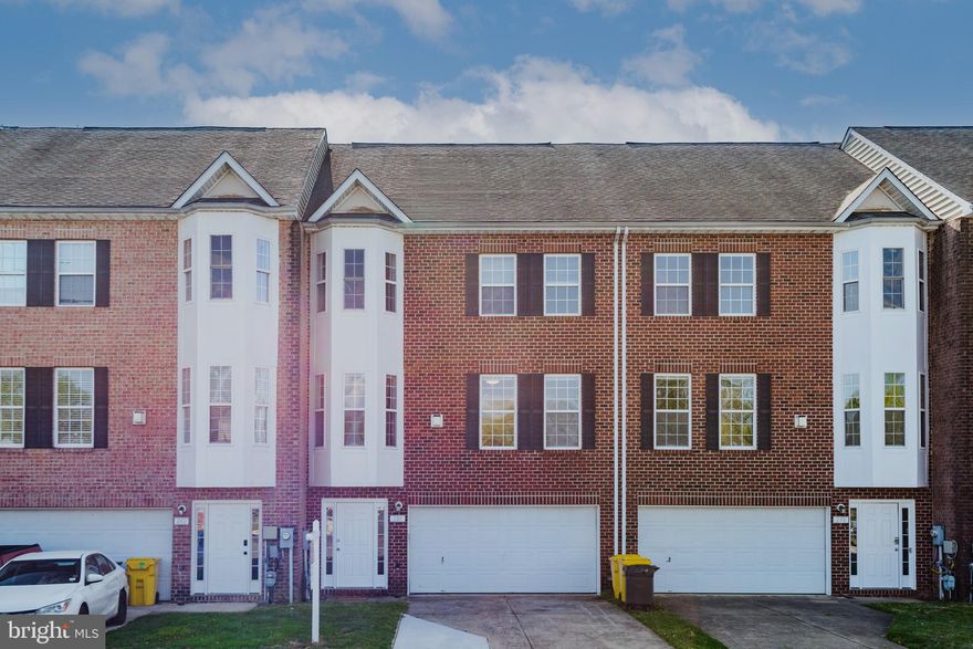 Brick front townhome on an expanded lot offering four levels and over 3,200 square feet of contemporary living space—flooded with natural light throughout. (Note: tax records are incorrect.) The open, recently updated floor plan features high ceilings, gleaming hardwood floors, and a gas fireplace. The modern kitchen includes quartz counter tops, brand new appliances and French Doors that lead to large serene deck overlooking private park reserve. Separate laundry room with washer/dryer off the kitchen. Upstairs, the expansive primary suite offers a walk-in closet and spa-like bath with dual vanity, soaking tub, separate shower, and private water closet. The fourth-floor loft—complete with skylight—makes the perfect office, playroom, or guest retreat. The entry-level family room opens to a private fenced yard and patio, ideal for entertaining. A two-car front-loading garage adds convenience and storage. Backing to protected park-like green space with mature trees and open lawn—never to be developed—this home combines tranquility with accessibility. Conveniently located near BW Parkway, ICC, I-95, Fort Meade, and shopping