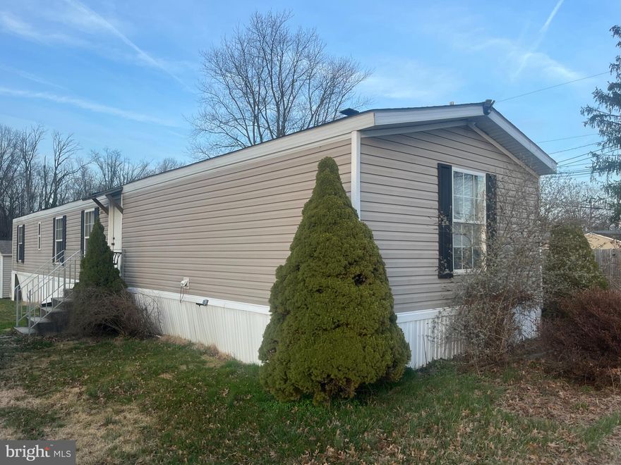 2009 single wide mobile home with 1200 sq.ft. and 3 bedrooms and 2 bathrooms on AMAZING LOT that backs to large field and woods. Small storage shed for extra space and large She/He-Shed that can be used as an office or play space. Newer hot water heater, propane stove and huge refrigerator and washer/dryer (all convey!). Central air, propane heat, and public water and sewer. Home needs flooring replaced throughout so priced accordingly.  Lot rent is $490/month and includes water, sewer and trash. No dogs allowed.  Buyers must be approved by Lazy Acres Park management.