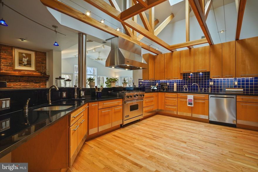 The epitome of one-level living with a stunning, award-winning kitchen and custom updates throughout. Set on a cul de sac amongst the trees on a 1+ acre lot, it's ADA-friendly. The true gem of the home is the outstanding kitchen with vaulted ceilings, wood beams, high-end appliances, and generous wood slab cabinetry paired with ample counter space. The breakfast room with brick fireplace provides original charm. Even cloudy days are bright in the sunroom with skylights and oversized windows framing beautiful views. The flexible walk-out lower level offers space for house guests, entertaining with wet bar and wine cellar, and a huge, unfinished area for storage and a workshop. The screened porch is a delightful place to relax, and spanning the back of the home is a deck with access from the main bedroom suite, living room and porch. Beautiful landscaping and hardscaping have been cultivated over the years by the seller, along with the meticulous maintenance of the property. Newer HVAC in 2022, and in 2023 - new water heater, whole home generator, water filter, and roof. From the street, one can not tell how stunning, comfortable and architecturally interesting this home is!