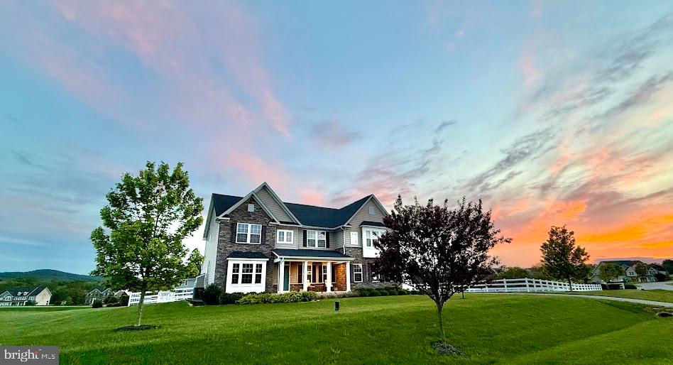 Welcome to the home of your dreams in the coveted Ramsburg Estates. This gorgeous 4 bedroom, 3.5 bathroom residence sits on 1.26 acres of fenced yard with sweeping views of Sugarloaf Mountain and breathtaking sunsets.
Step inside through the wide front porch into a dramatic double-height foyer. The main level includes an office, formal dining room, and a spacious family room that flows seamlessly into a gourmet kitchen- perfect for entertaining. The chef's kitchen boasts granite countertops, a huge island, upgraded appliances, a walk-in pantry, and plenty of cabinetry. From here, walk out to a beautifully designed back deck that provides both covered and uncovered outdoor living areas. A convenient mudroom connects the kitchen to the 2-car garage.
Upstairs, the loft landing offers a cozy retreat, alongside a full guest bath and laundry room. The luxurious primary suite showcases tray ceilings, dual walk-in closets, and spa-like ensuite bathroom with an oversized shower and double vanity. Three large additional bedrooms complete this level, including one with a private ensuite.
The partially finished basement extends your living space with an entertainment area, home gym, and abundant storage. Don't miss your chance to own this exceptional property, combining luxury, comfort, and spectacular views.