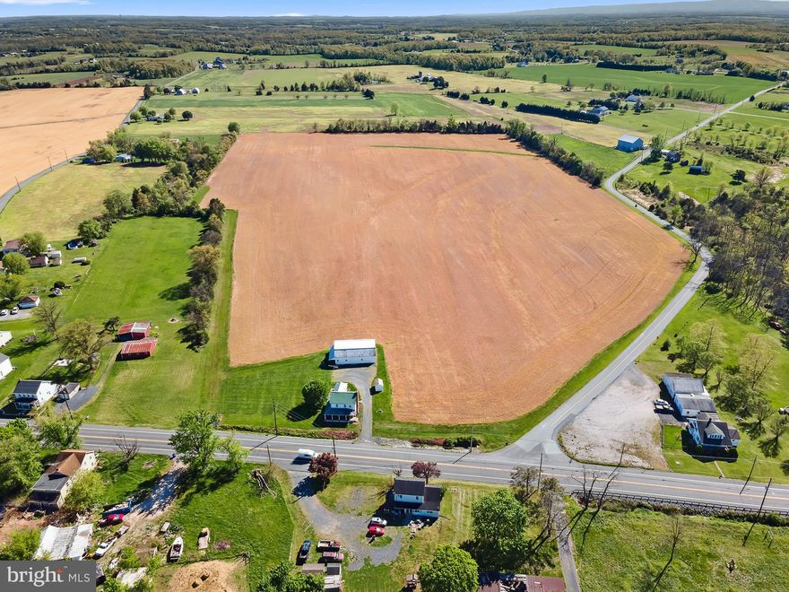 39 completely flat acres, 32 of which are tillable, await you at 3691 Baltimore Pike. This property offers so much versatility. It is currently enrolled in the Clean and Green program, however, due to township zoning, it is eligible for subdivision and could also be a mixed-use commercial, or residential site. With ample road frontage, this is a prime location for whatever your dreams may be as it is situated only a few minutes north of the heart of Littlestown and along a very popular commuter route. The property features a 2 bedroom 2 bath farmhouse that has been very well maintained  with more recent updates including windows, porch, furnace, and water heater. There is a large barn outbuilding that could easily convert to stalls with water and electric, and 2 additional smaller outbuildings that could be used for an office or storage. This property is truly a blank canvas for so many different uses and has so much potential for development, or simply keep it in crop as it currently sits. There are also approximately 3 wooded acres on the other side of Speelman-Klinger Rd with a stream.