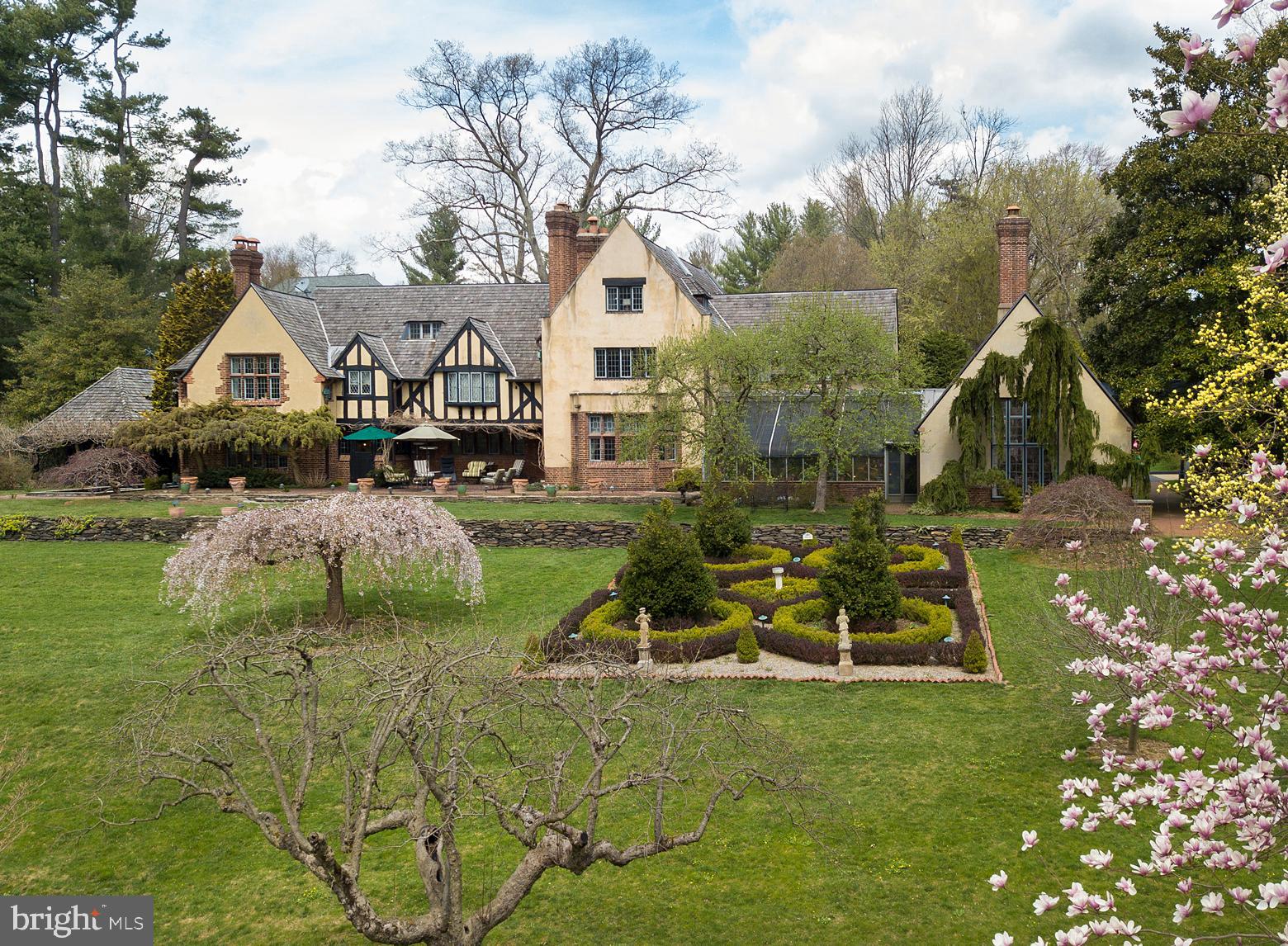 Under the careful and exacting eye of the same owner for the past 35 years, "Springwood", an extraordinary estate designed by Mellor, Meigs and Howe in 1915 is now offered to the market. Comprised of three parcels, totaling five and a half acres, the French Norman stone, brick and dash home is set off a long winding drive, positioned to enjoy its rolling southern lawns, croquet court, woods, stream, stone terraces and moon garden. "The covered terrace is situated at a short distance from the house in order to not darken any of the rooms, and provided with ornamental wrought-iron grilles to the north and brick openings to the east, in order to attract any Summer breeze, while the connection between it and the house takes one past the reflecting pool and under the sleeping porch." Elegant formal rooms graced by original lead -paned windows, limestone surround fireplaces and wide planked floors connect by hallways detailed with hand hewed beams and original artisan crafted plaster walls. A greenhouse adds natural beauty and romance as it joins the gracious Dining Room to the "Club Room," featuring a dramatic barrel ceiling and oversized fireplace. Unspoiled by fleeting design trends the home itself has been specifically maintained with some rooms, such as a projection room, paneled in Cuban mahogany, repurposed to meet the desires of the current marketplace. Four large bedrooms can be found on the second level, including a Master suite with large bath, sitting room, reach-in as well as generous walk-in closets and the original step-down sleeping porch. The third level offers an additional three rooms and large shared hall bath. There is no home as simultaneously impressive as it is welcoming and inviting.
