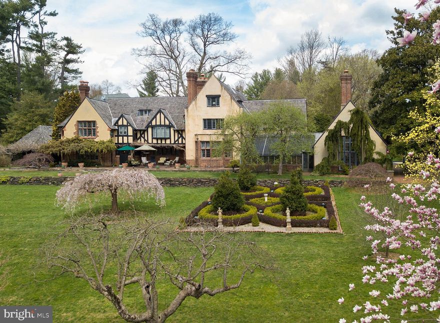 Under the careful and exacting eye of the same owner for the past 35 years, "Springwood", an extraordinary estate designed by Mellor, Meigs and Howe in 1915 is now offered to the market. Comprised of three parcels, totaling five and a half acres, the French Norman stone, brick and dash home is set off a long winding drive, positioned to enjoy its rolling southern lawns, croquet court, woods, stream, stone terraces and moon garden. "The covered terrace is situated at a short distance from the house in order to not darken any of the rooms, and provided with ornamental wrought-iron grilles to the north and brick openings to the east, in order to attract any Summer breeze, while the connection between it and the house takes one past the reflecting  pool and under the sleeping porch." Elegant formal rooms graced by original lead -paned windows, limestone surround fireplaces and wide planked floors connect by hallways detailed with hand hewed beams and original artisan crafted plaster walls. A greenhouse adds natural beauty and romance as it joins the gracious Dining Room to the "Club Room," featuring a dramatic barrel ceiling and oversized fireplace.  Unspoiled by fleeting design trends the home itself has been specifically maintained with some rooms, such as a projection room, paneled in Cuban mahogany, repurposed to meet the desires of the current marketplace. Four large bedrooms can be found on the second level, including a Master suite with large bath, sitting room, reach-in as well as generous walk-in closets and the original step-down sleeping porch. The third level offers an additional three rooms and large shared hall bath. There is no home as simultaneously impressive as it is welcoming and inviting.