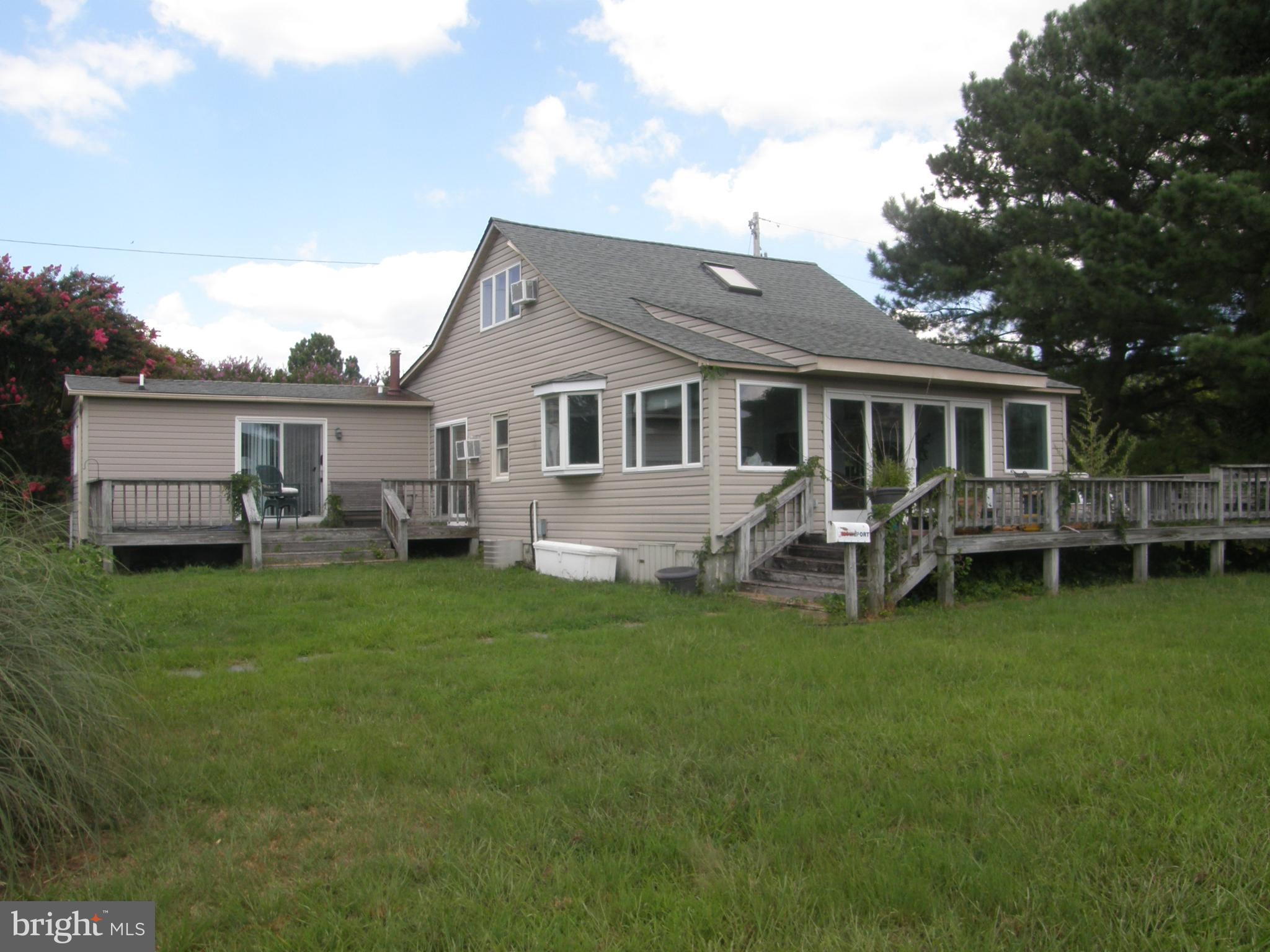 Terrific value in this 3 bedroom 2 bath Cape Cod perched on a nice elevated lot with over 400 feet of waterfront improved with extensive pier/dockage (in need of extensive repair but clearly existing) that was used as a residence with commercial marina suitable to provide 25-35 rental slips. Secound building is his/hers bath house with storage and additional apartment. Zoning is residential but has identified as "Homeport Marina" and would be recognized as non-conforming approved useage as Marina. Suitable for just a waterfront residence. Piers on Northwest Corner do not access the property. Plat available for review.