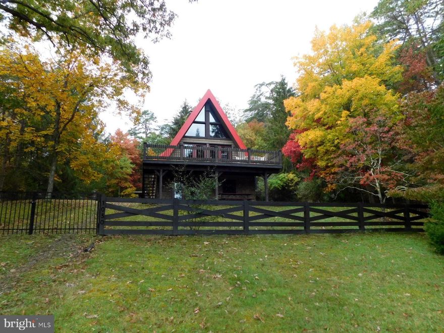 Charming 2BR 2BA Chalet nestled on the hillside on over six acres of trees and fields with a small stream near the edge of property.  Enjoy the warmth from the fireplace on the main floor as you gaze at the view through the floor to ceiling windows.  Primary bedroom is on the main floor for easy access as is the laundry.   The walk out daylight basement also has a living area with it's own fireplace and another bedroom.    Upstairs is a small loft and safe room.    The deck is great for entertaining and watching the wildlife.  Travertine Tile in Dining Room and Kitchen, Hardwood in Living Room, Primary BR and Mud Room, Bathroom is Tile.  Stainless Steel Appliances and Granite Countertops, this place has it all.  Ten minute drive from the shops and restaurants in Wardensville 2 hours from DC.