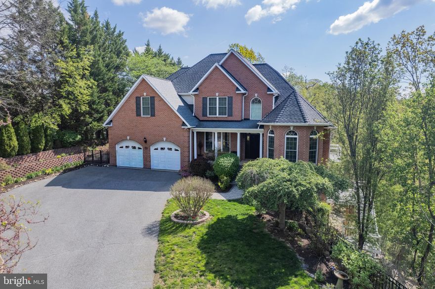 Welcome home to a property that feels like a retreat the moment you step inside. Originally custom built by the builder as his personal residence, this home reflects a level of craftsmanship and thoughtful detail that sets it apart from the moment you arrive. The soaring cathedral ceiling foyer sets the tone — light, open, and gracious. The main level is thoughtfully designed for both everyday living and effortful entertaining: a living room anchored by a stone fireplace with cathedral ceiling, a dining room with a bay window that frames the outdoors, an updated eat-in kitchen with granite countertops, tile backsplash, and custom cabinetry, and a cozy family room for added comfort and space. Step outside to a screened-in porch or deck and take in the views — they're genuinely stunning all year around. The main level primary suite is a private sanctuary, complete with a sitting area, balcony, and a full primary bath. Upstairs, three additional bedrooms and a full bath offer generous space for family or guests. The lower level surprises at every turn — filled with natural light and above-grade living, it features a true bedroom, full bath, mini kitchenette, and rec room that walks out to a deck overlooking a tiered garden landscape with cascading retaining walls and lush plantings. A dedicated workroom and abundant storage round out the space, and a sub-basement adds even more possibility — think wine cellar, hobby space, or long-term storage. Beautiful hardwood floors carry through the main and upper levels; luxury vinyl plank brings warmth and durability to the lower level. This is a home with room to grow, room to breathe, privacy, and views that never get old. See video link for AI generated walkthrough!