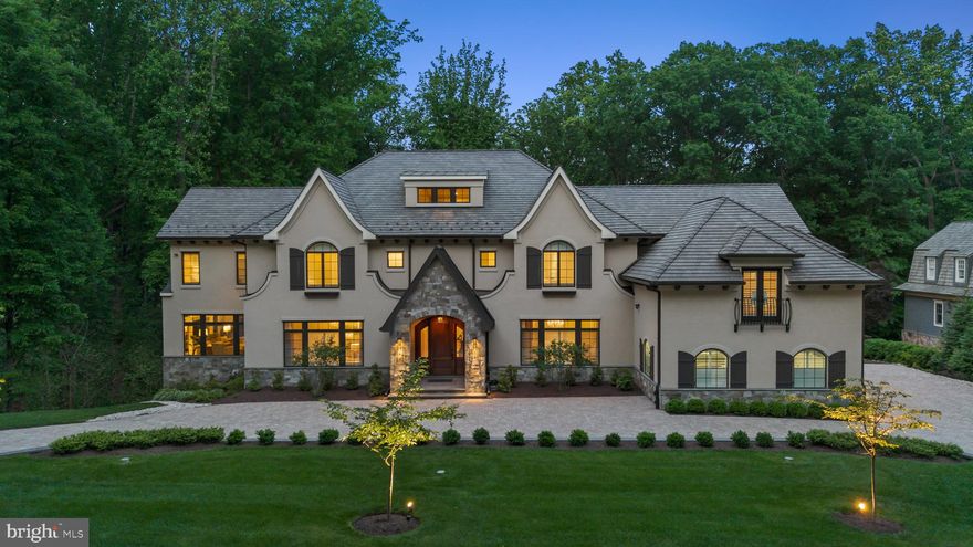 NEW PRICE..... Like a page out of Architectural Digest, this incredible French Provincial-style residence has every characteristic of that iconic style; symmetrical pitched rooflines, arched windows adorned with shutters and window boxes, and a classic façade of dry-stacked stone and stucco with an elevator to access all levels.  Backing to a conservation area with approx 8 miles of walking trails of Merry-Go-Round Farm, the walls of windows and glass doors offer incredible front-to-back sight lines that seamlessly blend the outdoors into the fabric of the home.  There are 8 bedrooms, 8 full baths and 2 powder rooms.  

Enhanced by intricate ceiling detail, four fireplaces, art niches, and scrolled wrought-iron staircases, the carefully curated finishes are masterfully incorporated into a design that is timeless.  The primary rooms include formal living and dining rooms, a handsome library, a custom butler’s pantry, a prep kitchen for entertaining, and a beautiful two-story family room with incredible views of the grounds.  Inviting in every season, the sunroom features a fireplace, an exposed brick wall and three walls of windows overlooking the surrounding trees.  The primary kitchen is every chef’s dream with a twelve-foot island, professional-series appliances, and state-of-the-art cabinetry with Old World style.  The main level opens to a beautiful two-level terrace with an expansive outdoor kitchen, a stunning stone fireplace and the perfect setting for alfresco dining.  

Every bedroom in this home offers a luxurious private full bath, ample space for furnishings and walk-in closets.  The primary suite features a Juliet balcony, an incredible custom dressing room and a bath with a steam room, sunken tub, oversized shower and dual vanities.  Ascend to the attic level and find the flexible living space of any buyer’s imagination…it’s the perfect teen hangout, artist studio, guest space or home office, complete with its own full bath.   The owners put the same attention to detail into the design of the lower level, which offers a gorgeous wine cellar, a two-tiered theater, a home fitness room, and an expansive bedroom suite.  

The massive lower-level recreation room includes a kitchen with a full refrigerator and microwave, bar seating, a fireplace and ample space for billiards and game tables.  10-foot ceilings add loft and light to the lower level, and French doors open to the outdoor terrace.  Every consideration to the modern lifestyle was made in this home-there is finished and unfinished storage space, a state-of-the-art infrastructure, and a four-car garage.  

For the outdoor enthusiast, the location is unparalleled; Merry-Go-Round Farm offers approx 8 miles of equestrian and walking trails for its residents, stocked ponds for fishing, a community barn, open pastures and common areas usable for residents and is moments from the Potomac River and C&O Canal.  Just 10 minutes to Potomac Village in one direction and 10 minutes to the rolling hills of upper Montgomery County in the other, this elegant, timeless home embodies the very best of town-and-country living.