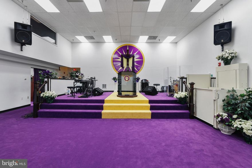 As you step through the stately foyer, you are immediately welcomed into a grand and graceful space that sets the tone for everything beyond it.  From there, you enter the fellowship and welcome area — a warm and inviting gathering place where community, conversation, and connection naturally flow.
Beyond the foyer lies the main sanctuary, a beautifully designed worship space.  The sanctuary features high ceilings, offering both openness and the potential for a future balcony area that could overlook the existing sanctuary. Throughout the sanctuary, you’ll notice royalty-colored purple plush carpet and seating, symbolizing reverence and distinction.
The pulpit area itself is expansive ,  offering ample room for musicians, and designed with elegance and visibility in mind.  For accessibility, the pulpit area features a compliant ADA lift ensuring accessibility for all.  Technologically, it's fully equipped with flooring and wall outlets.

This property provides a men and women’s congregational restroom for guests and members alike, along with a neutral gender restroom. In addition it also have an additional restroom on the upper level with a shower, located just across from the Pastor’s office in the conference suite.

The Pastor’s office is comfortably situated adjacent to the spacious upper-level conference room, ideal for leadership meetings or private reflection.  The upper level conference room offers a unique architectural touch, overlooking the sanctuary through elegant tenant windows, adding undistracted visibility to the design.

Upgrades that have been made are:
A brand-new HVAC system providing modern central heating and air conditioning,
along with a new roof, offering peace of mind and long-term durability.

For small stand up gatherings , there is a kitchenette and modest walk-through serving area conveniently adjacent to the sanctuary that's perfect for light refreshments or serving the congregation after service.

This property includes a use and occupancy permit that accommodates up to 169 parking spaces.  It has plenty of shared parking within the complex, providing convenience for all who attend.

 This building is also a modular building and easily reconfigured to fit most business needs which will provide the flexibility to accommodate a conference, seminar, event space, academy, daycare, school  office space or any type of retail business.

It's located in the heart of Lanham Maryland, just 5  minutes from Route 495/beltway and 10 minutes to BW Parkway.

This is an exceptional worship space that provides a stately sanctuary with great accommodations, ready to welcome its next chapter of worship, community and service.