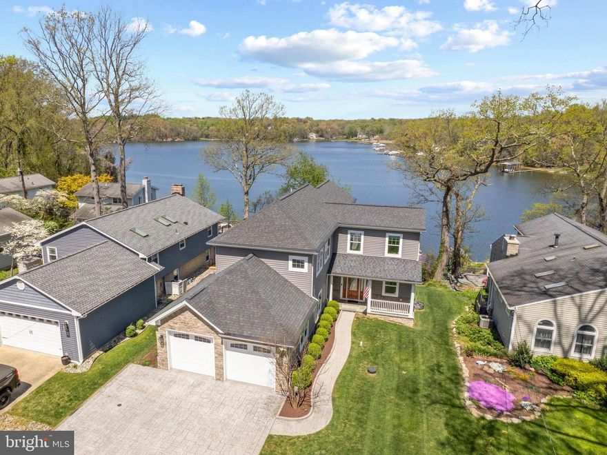 Exquisite waterfront sanctuary, offering breathtaking vistas of the tranquil Severn River. The expert siting of this home on a hillside lot overlooking the water captures endless views from almost every room. A complete renovation in 2016 has transformed this property into a haven of luxury and comfort. Step into the foyer to be immediately greeted by the framed water views through the wall of windows in the sunken living room and marvel at the abundance of natural light beaming in. Adorned with a floor-to-ceiling stone fireplace, vaulted ceilings, and recessed lighting, the living space exudes warmth and sophistication. The adjacent dining area, with French doors leading to a sprawling Trex deck, promises unforgettable sunrise and sunset views and provides a perfect place for entertaining or relaxing. The gourmet kitchen boasts Quartz countertops, custom cabinets with pull-out shelves and soft close feature, and top-of-the-line GE Monogram stainless steel appliances; all the extras that are sure to satisfy even the most accomplished chef. Work from home in the main-level corner office, offering inspiring water views. The upper level hosts a lavish Primary bedroom suite with a private balcony, walk-in closet, and spa-like en suite bath. The serene, peaceful views from the balcony are unsurpassed and an ideal backdrop for your morning and evening routine. Two additional bedrooms, a laundry room, and a full bath complete the upper level. The lower level is an entertainer's paradise, featuring a second fireplace, and a magnificent bar fully equipped with dishwasher drawers, ice machine and kegerator.  Enjoy hosting gatherings large and small! The additional bedroom with full bath provides a convenient space for overnight guests. Open the patio doors and let the party spill out onto the stone patio overlooking the landscaped yard and the sparkling water of the river. Head on down to the water's edge to appreciate the deep water pier, 2 coveted and recently reconstructed boathouses with lifts and additional 60-foot boat slip.  The perfect trifecta for an avid boater.  The prime location on the Severn River makes it easy to cruise to Annapolis, the Chesapeake Bay and beyond.  Experience the ultimate waterfront lifestyle in this meticulously crafted retreat.