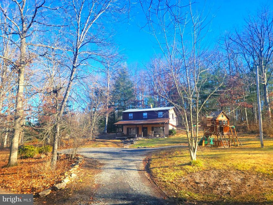 WELCOME TO YOUR PARADISE IN THE WOODS! Located just barely into Morgan County, just over the Berkeley/Morgan County line, you'll feel far from everything, while still being close to everything!  End every day in the peace and tranquility of your private homestead. Say goodbye to HOAs and restrictions! This property is unrestricted and ready for you to call home. On the outside, the home has a metal roof over the main portion of the home and a brand new shingle roof over the HUGE front porch. The home even comes with the "country front porch starter kit" -- two rocking chairs! Much of the siding has been recently replaced and/or repainted.  Two sheds and playground equipment complete the package on the outside. Inside, you're immediately greeted with the warm feeling of being home. Tastefully exposed beams and a two-sided chimney with a wood stove on the kitchen side and and wood insert on the living room side greet you as you enter the home. The kitchen is large, with an island, and is outfitted with modern stainless steel appliances. The pantry is massive, too! Heading up the rough-hewn log steps, you'll find three comfortable bedrooms, as well as a brand new bathroom. The laundry is also on this level, in the mud room where there is a back door out of the home on this level, too. Trade your current neighbors for trees and your sneakers for boots and prepare to call this beautiful house "HOME"! IF YOU LIKE WHAT YOU SEE, CALL                !!!!!!!!!!!