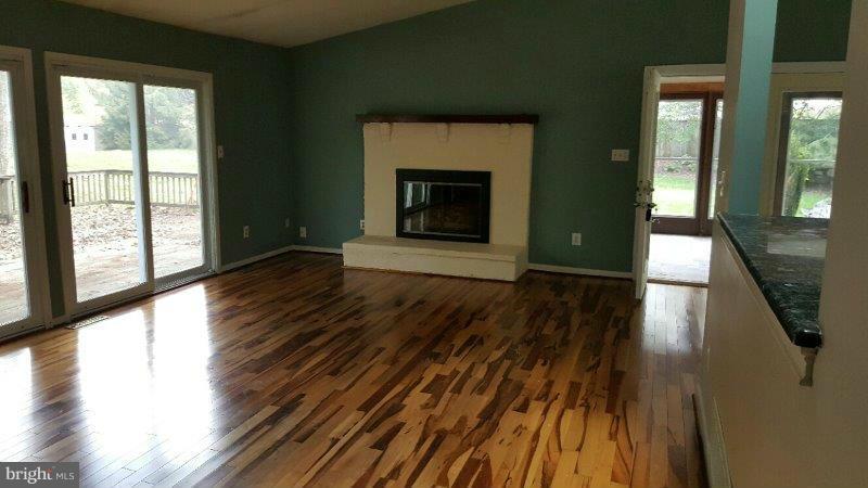 This home is a blank canvas and the perfect opportunity for a buyer to make this house a home. Large deck and screened porch. Very private, wooded setting with mature trees and winding stream on 3.83 acres. Other buildings include a 2 car garage, shed and barn. Conveniently located. Being sold as is.