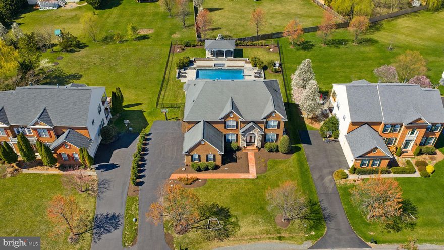 Experience unmatched luxury in the heart of Ashburn’s highly sought-after Belle Terra community! This exceptional east-facing estate offers over 6,800 finished square feet of refined living space and more than $500,000 invested in a truly resort-style backyard oasis.

Step outside and be captivated by your private retreat, featuring a custom NV Blu-built heated saltwater pool and spa, enhanced with stunning spillover and sheer descent water features, extensive hardscaping, and elegant retaining walls. Entertain year-round beneath the covered open-air pavilion, complete with a striking herringbone fireplace, or host unforgettable gatherings on the recently replaced oversized Trex deck—perfect for becoming the envy of the neighborhood.

Inside, the home continues to impress with 5 spacious bedrooms and 4.5 bathrooms upstairs, plus a main-level bedroom ideal for guests or multigenerational living. Enjoy the warmth and charm of four interior fireplaces, along with peace of mind from recent upgrades including HVAC, hot water heater, and roof.

The chef’s kitchen is designed to inspire, showcasing a 48-inch KitchenAid refrigerator/freezer, stainless steel appliances, an expansive island with a separate vegetable sink, and a beverage refrigerator—perfect for both daily living and entertaining.

The walk-out basement is truly an entertainer’s dream, offering direct pool access, a massive custom bar with ice maker, commercial-grade beer refrigerators, dishwasher, and sink. Additional highlights include a pool table/game area, a private gym or office space, and a stylishly updated full bathroom.

All of this is ideally located just minutes from the Silver Line Metro, approximately 7 miles to Dulles International Airport, and with easy access to the Dulles Greenway—making commuting effortless. Zoned for the top-rated Briar Woods High School pyramid, this home offers both luxury and convenience.

This is more than a home—it’s a lifestyle. Come claim your place as one of Belle Terra’s finest and most admired residences!