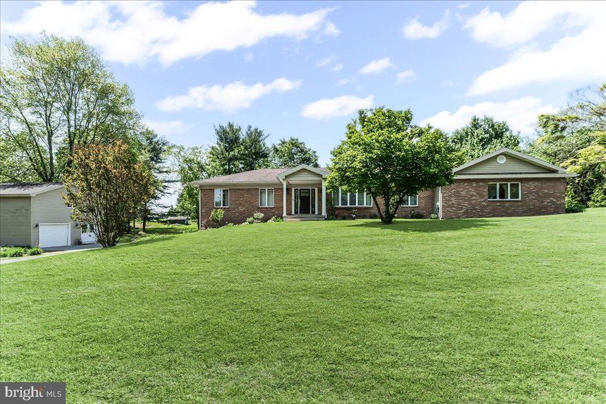 Imagine a brick rancher on an acre lot with 5 bedrooms, 3 ½ baths, an attached garage and a finished basement. Add a lovely first floor in law suite and finish it with a detached garage, complete with workshop and second floor loft, for all your hobbies and projects, and your search is complete! The main house is open and airy with updated flooring and a living room to dining area combination that opens to a lovely, updated kitchen that comes complete with a large island, farm sink, stainless appliances and lots of white cabinets that are topped with gleaming quartz. Family room opens off the kitchen in the popular floor plan of 2025! Large opening, from the family room- kitchen area draws everyone to the sunroom, complete with a ceramic tile floor, ceiling fan and sliders to the patio—a perfect spot for those evening meals or morning cups of coffee. Primary bedroom suite features gleaming cherry floors, a walk-in closet with organizers and an updated bath. The additional 2 bedrooms, with ceiling fans, are easily serviced by the hall bath and one bedroom has built in beds with dressers!  Finished basement features a fourth bedroom, with an outside entrance, rec room, laundry room and a powder room with an unfinished shower. The 2008 addition of the in-law area could also be used as additional living area for the main house.  Eat in kitchen, with custom cabinetry, laundry room with a large hidden storage area, living room, office area, bedroom, sunroom and bath combine to create an amazing bright and airy space. Finally, to complete the picture is the detached garage area, with room for a workshop, storage for your lawn equipment and a walk up second floor that is perfect for your hobbies or a getaway area (it was designed to house an amazing model railroad display).  All of this on a 1-acre lot with lovely plantings and a level back yard for all your outdoor activities as well as easy access to 896 for commuting north and south.