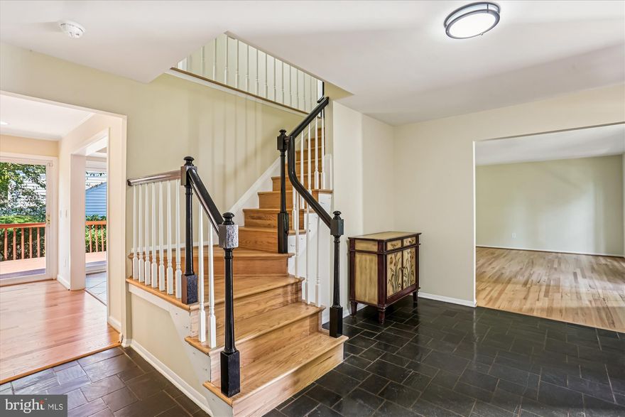 A classic colonial in Fox Hills West.  This home features 5 bedrooms, 3 full bathrooms, one half bath, and hardwoods throughout.  Enter the home from the covered porch into the expanded foyer with slate flooring.  To the right you will find the living room with floor to ceiling windows, gleaming hardwoods and fresh paint.  The living room leads directly into the nicely sized dining room, perfect for large gatherings.  From the foyer to the left, you will find a private office with a floor to ceiling window, wainscoting, chair rail and fresh paint.  The kitchen and family are on the back side of the house.  The kitchen includes updated cabinets, granite countertops, double pantry, seating, stainless steel refrigerator, built-in microwave and stove/ range.  Enjoy the oversized window and sliding glass door onto the deck from the kitchen.   The family room includes recessed lighting, wood burning fireplace, wet bar, and sliding glass door to the patio.  Just off of the family room is a spa like full bathroom with walk in shower, sink, and toilet that is handicap accessible.  Before entering the garage you will enter the laundry area with fill sized washer and dryer, and amble room for storage.  The upper level includes a primary suite (13x27) with walk-in closet, and a private bath.  The bathroom includes a stall shower, sink and toilet.  The four secondary bedrooms are well sized with ample closets that share a hall bath with tub/shower combo and linen closet.  The lower level is finished for the movie lover.  With a full screen and projector, its a great place to relax.  The lower level also features a storage area and half bath.  The yard is beautifully landscaped and is fully fenced in.  Roof/ Windows/ HVAC - 2016, HWT 2023.  The home has been refreshed with all lighting, new paint and gleaming hardwoods.  The home is part of the Fox Hills Citizens Association.  FHWCA is an active association that hosts holiday events, ice cream socials, food trucks and more!  The home is walking distance to Cold Spring Elementary and Wootton High School.  There is transportation to Cabin John Middle School. Make this your home and experience the community of Fox Hills West!