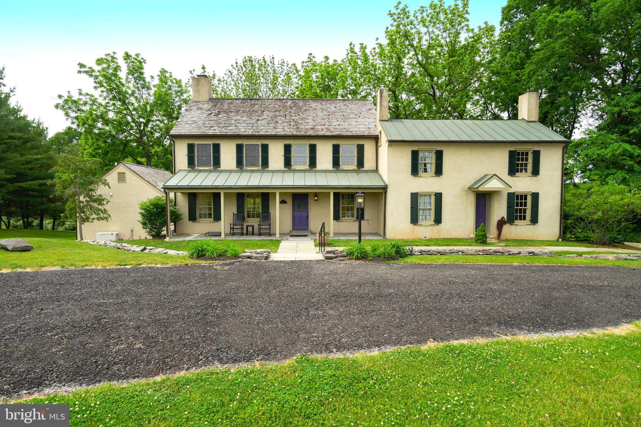 Beautifully situated on one of Solebury's most desirable roads, this fabulous home is an exquisite combination of serenity and drama; antique and modern; intimate and elegant! It was designed by renowned architect Lynn Taylor and built in 1992, incorporating a lovely 19th century cottage. From the traditional facade, the front door opens into the large open floor plan living area with gleaming hardwood floors, soaring ceilings and many windows that fill the space with light. A short flight of steps leading to an expansive dining area with a wall of windows. Just beyond is the large and inviting kitchen with ample room for several cooks. A peninsula has seating for six. The kitchen also has a beverage sink, counter and cupboards, two pantries and a door to the mudroom/drop zone. A short hallway off the main living space takes one into the "antique" section of the house currently used as an office, with its own door to the outside. Above is a pretty guest room with its own bath. Opposite the guest suite is a small space, also part of the old cottage. Here one of the old exterior windows now looks down into the kitchen. A skylight fills this room with light. Just beyond, and back in the main part of the home, is a gallery overlooking the living area, along with two bedrooms (one with a whimsical loft) and a jack-and-jill bathroom. Because the home was designed to be wheelchair accessible, a ramp of the same gorgeous hardwood goes from the living space to the dining room and kitchen, and extends through another gallery of windows and display space to the primary bedroom on the lower level. This beautiful suite, which looks out over the grounds to the stream and wood at the rear of the property has a gas fireplace; walk-in closet; shoe closet, linen closet; two vanities (one wheelchair height); roll-in shower; and a dressing area. The house has another lower level with two finished areas - just right for a large office, playroom, gym, craft area...endless possibilities. There is a walk-in storage room; large closet with shelves; a small workshop; 2 utility rooms; powder room; and tucked away under the old cottage a wine cellar. The property has an over-sized two-car garage with a storage room accessed from a small patio. There is a beautiful bluestone patio overlooking the rear lawns, and a picturesque rocking-chair-style front porch. This very special property has preserved farms to the rear and side and is across the road from many acres of preserved farm land.